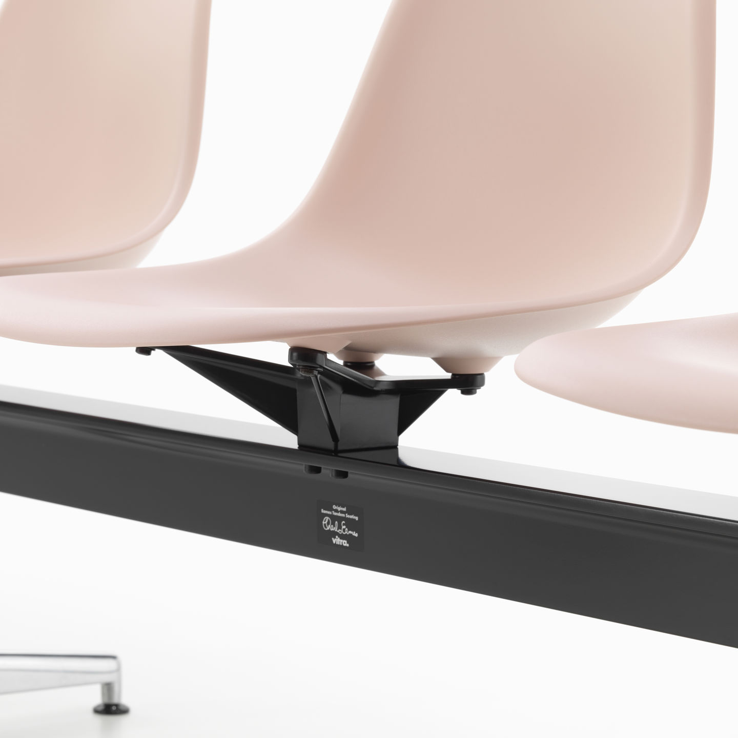 Detailaufnahme: Eames Plastic Side Chair RE auf Traverse von Vitra, Sitzschalen in zartem Rosa.