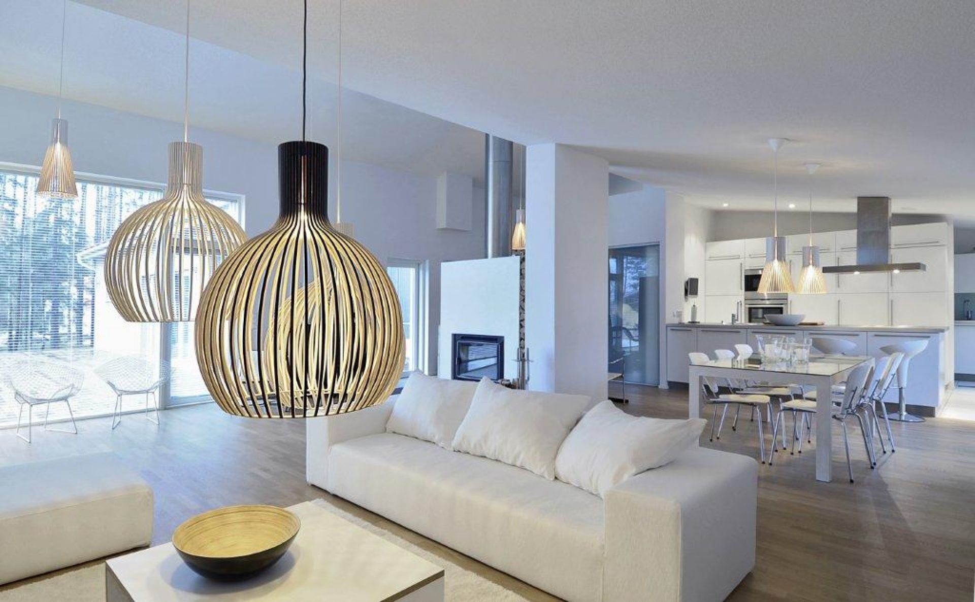Helle, moderne Wohnung mit Octo Pendelleuchten von Secto Design aus Holzfurnier über Sofa und Esstisch.