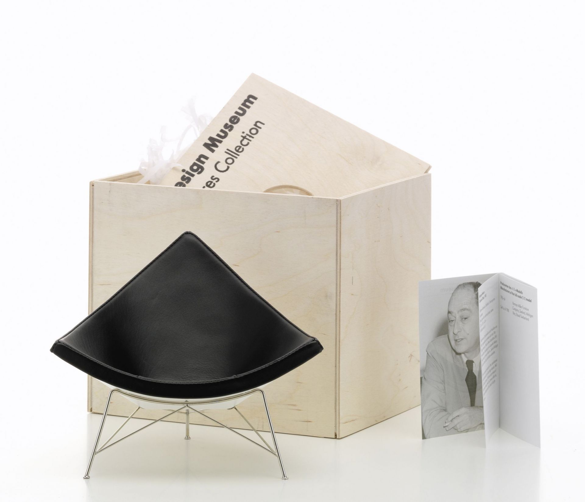 Produktfoto: Schwarzer Coconut Chair Miniatur Stuhl von Vitra, Designklassiker, Holzbox und Broschüre.
