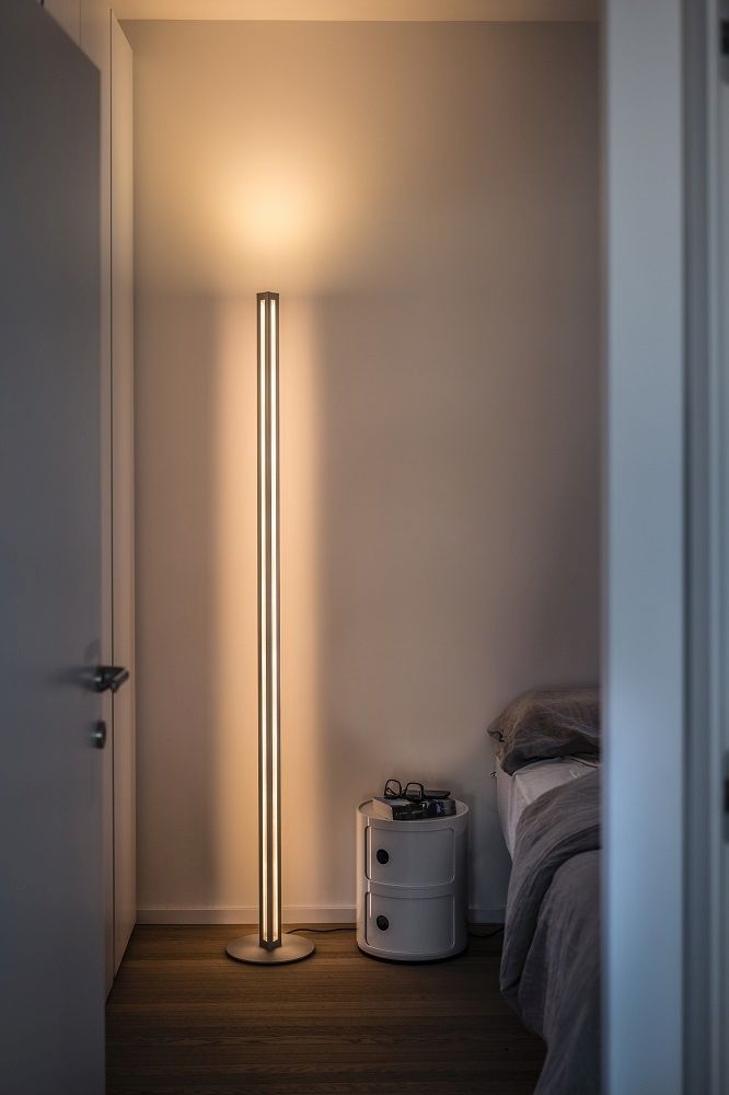 Chiaroscura Stehleuchte von Foscarini im Schlafzimmer: Moderne LED-Stehlampe mit warmem Licht neben Nachttisch.