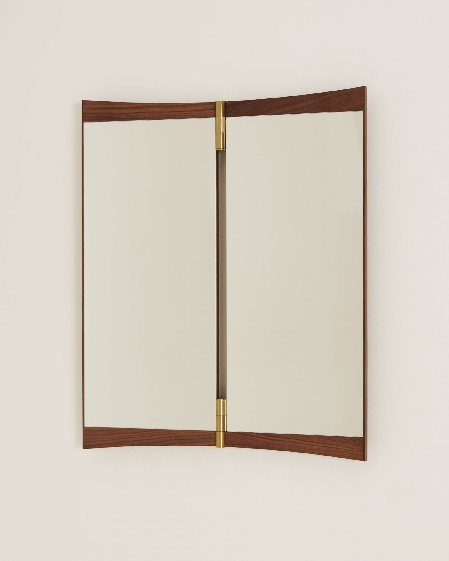 Gubi Vanity Wall Mirror 2 Wandspiegel mit Walnussrahmen und Messingscharnieren an einer weißen Wand.