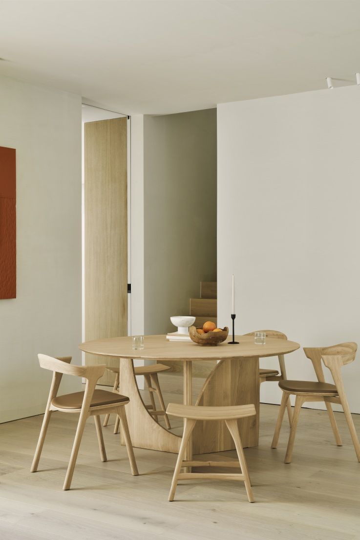 Ethnicraft Geometric Dining Table: Runder Esstisch aus hellem Holz mit passenden Stühlen in modernem Esszimmer.
