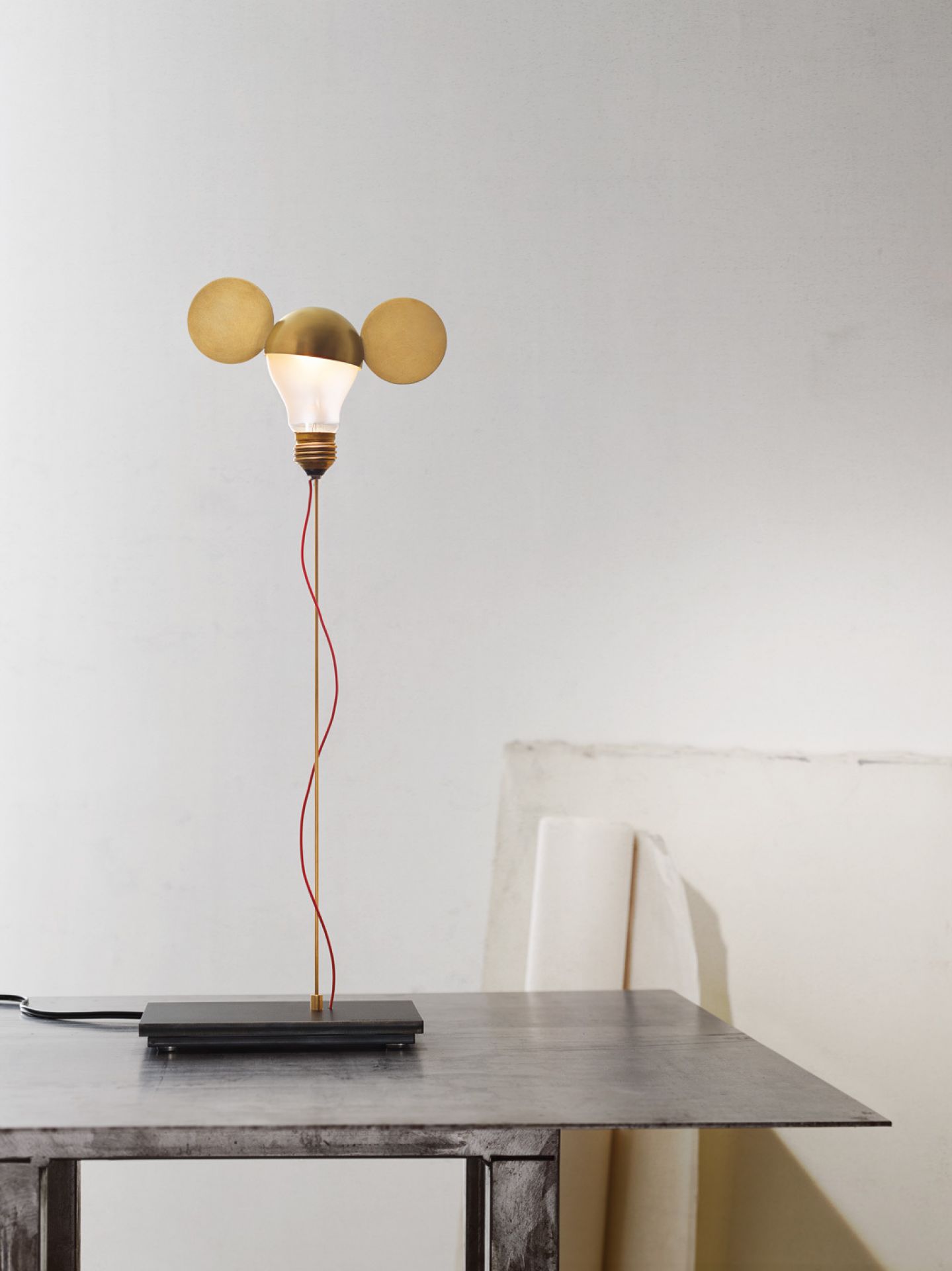I Ricchi Poveri Toto Tischleuchte von Ingo Maurer: Glühbirne mit roten Kabel und Messing Details.