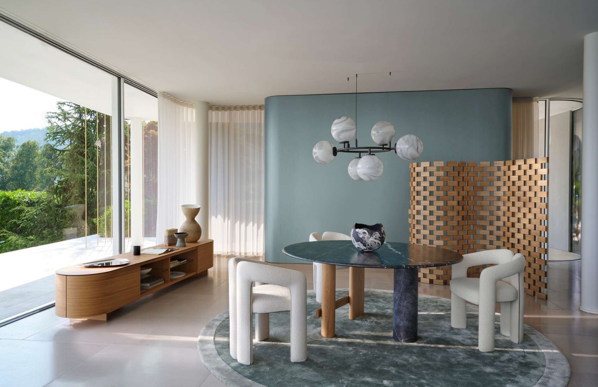 Helles Esszimmer mit Cassina 562 Dudet Sessel in Weiß, Marmortisch und moderner Einrichtung.