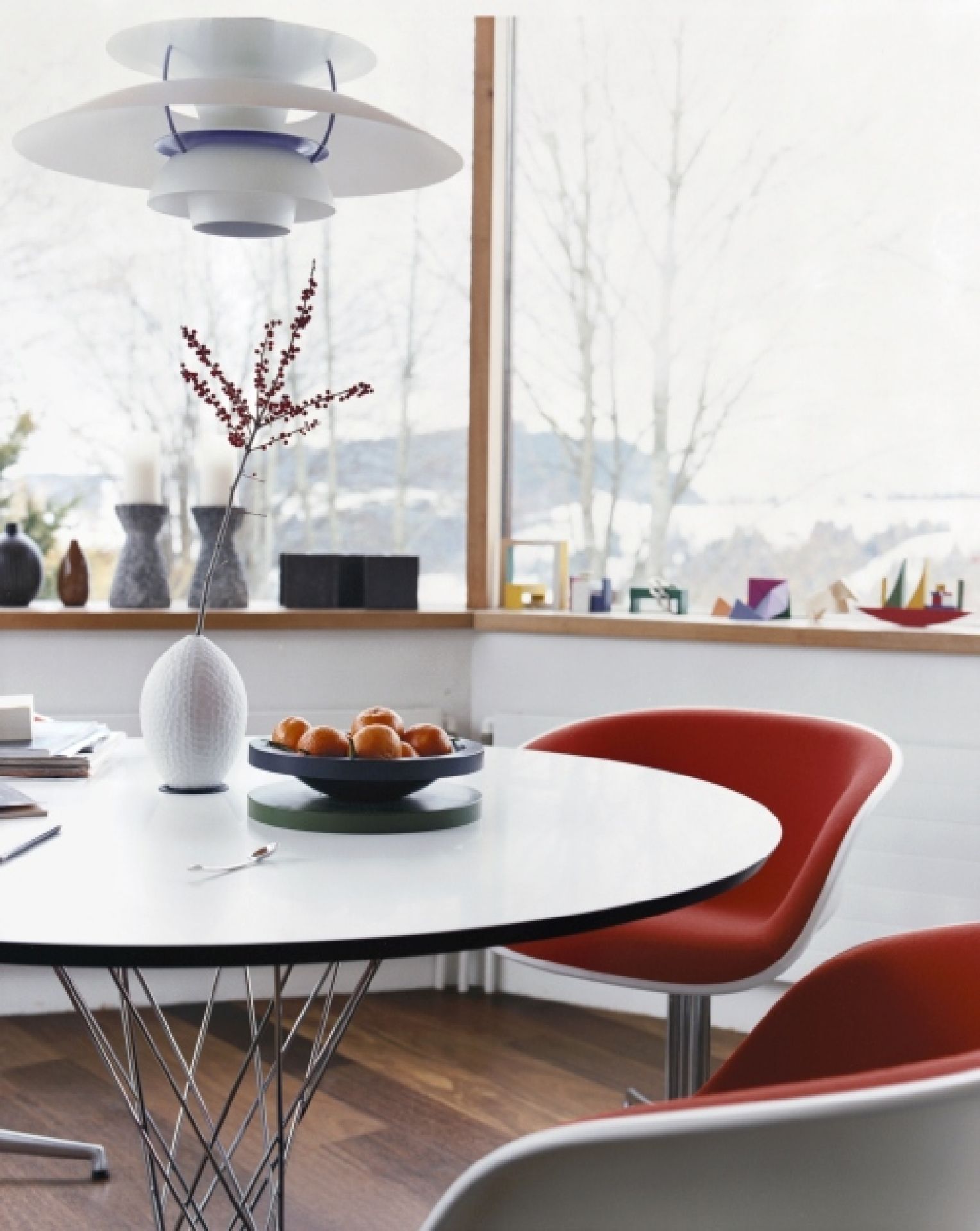 Vitra Noguchi Dining Table mit weißer Tischplatte und verchromtem Drahtgestell in modernem Esszimmer.