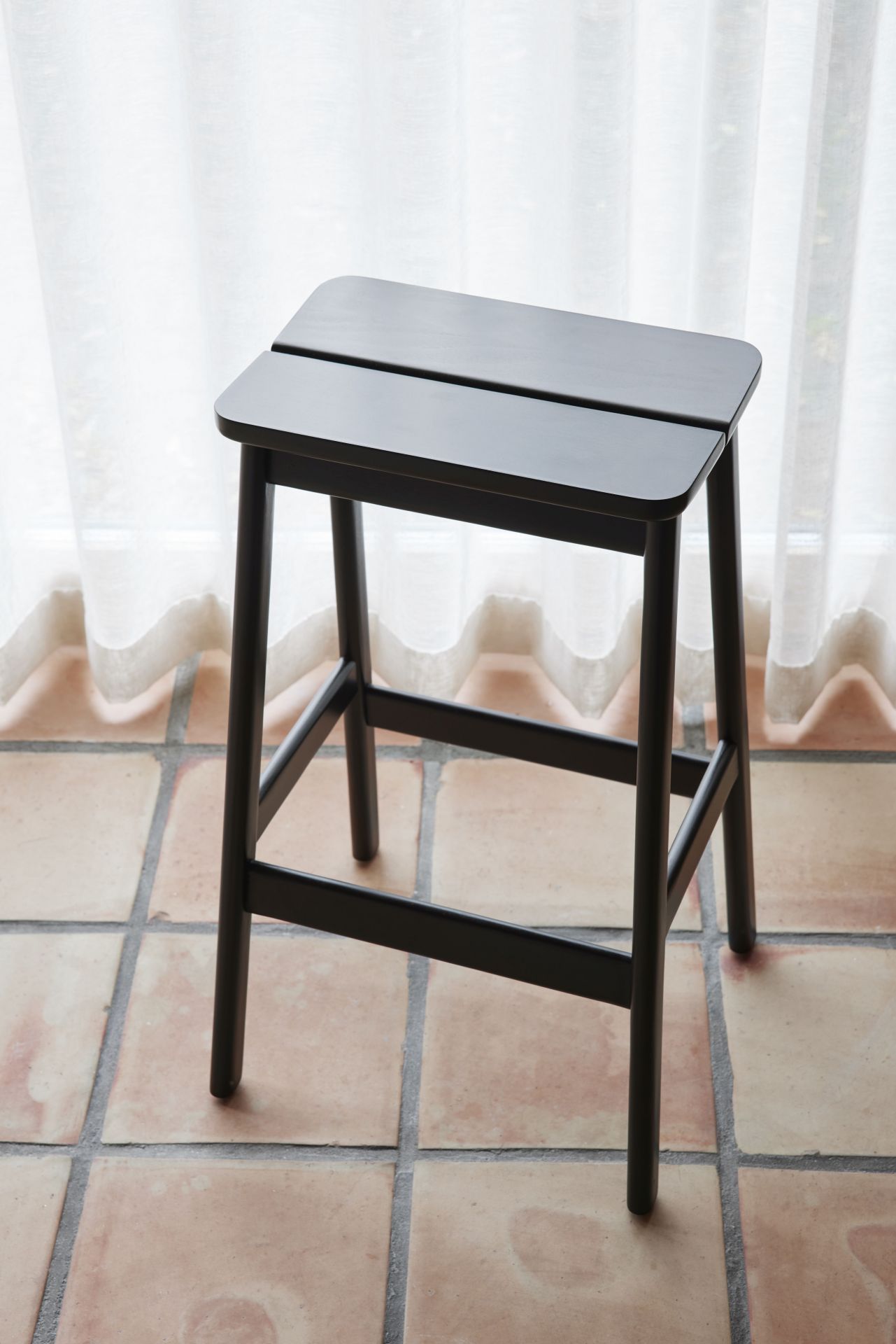 Angle Barhocker von Form & Refine, minimalistisches Design aus dunklem Holz, geeignet für Küche und Bar.