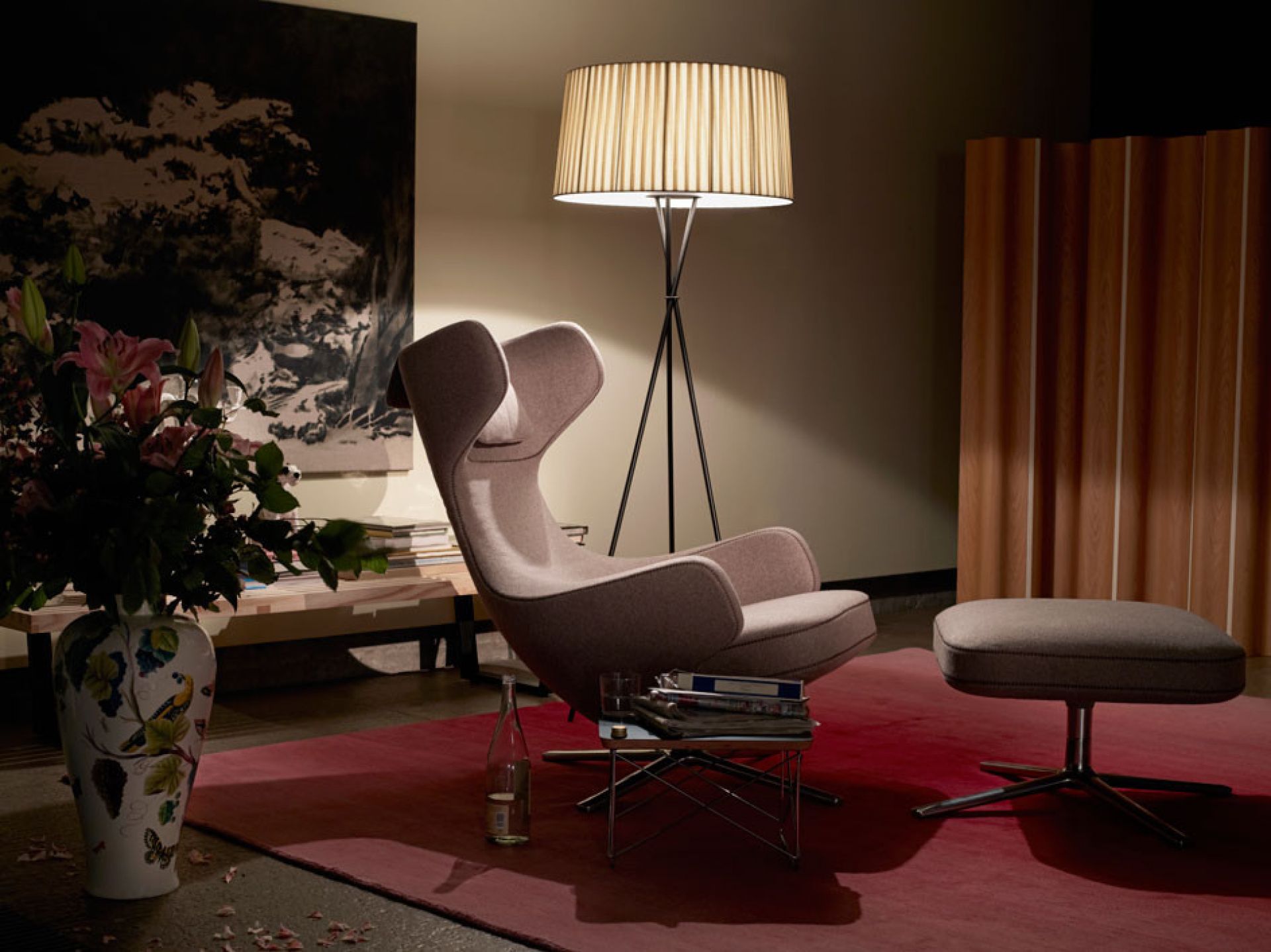 Vitra Grand Repos Sessel in Grau mit Hocker und Stehlampe auf rotem Teppich.