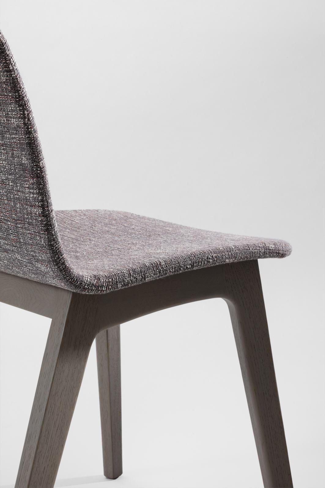 Detailaufnahme des Morph Plus Stuhls mit Vollpolsterung und Holzgestell, geeignet für Esszimmer und Büro.