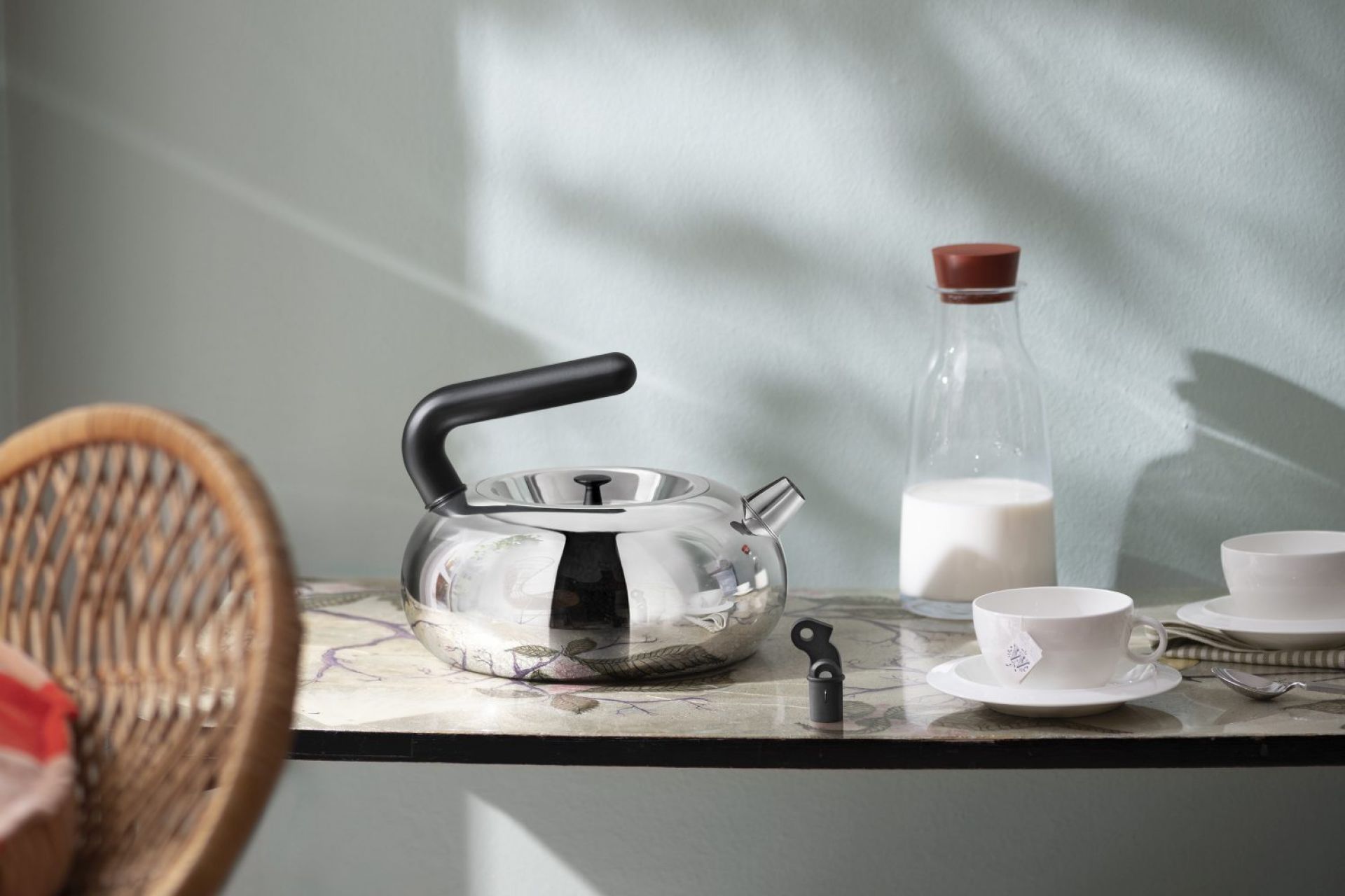 Edelstahl Wasserkessel "Irony Bulbul" von Alessi, Limited Edition, auf Tisch mit Milchflasche und Teetasse.