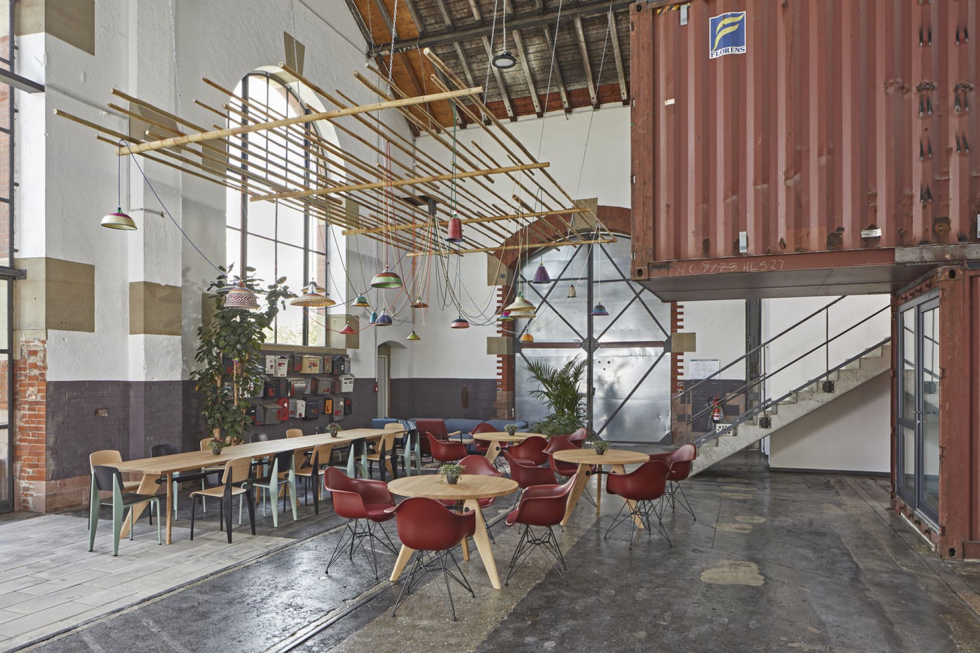 Innenaufnahme eines Industrieraums mit Vitra Stühlen und Tischen, ideal für Büro oder Konferenz.