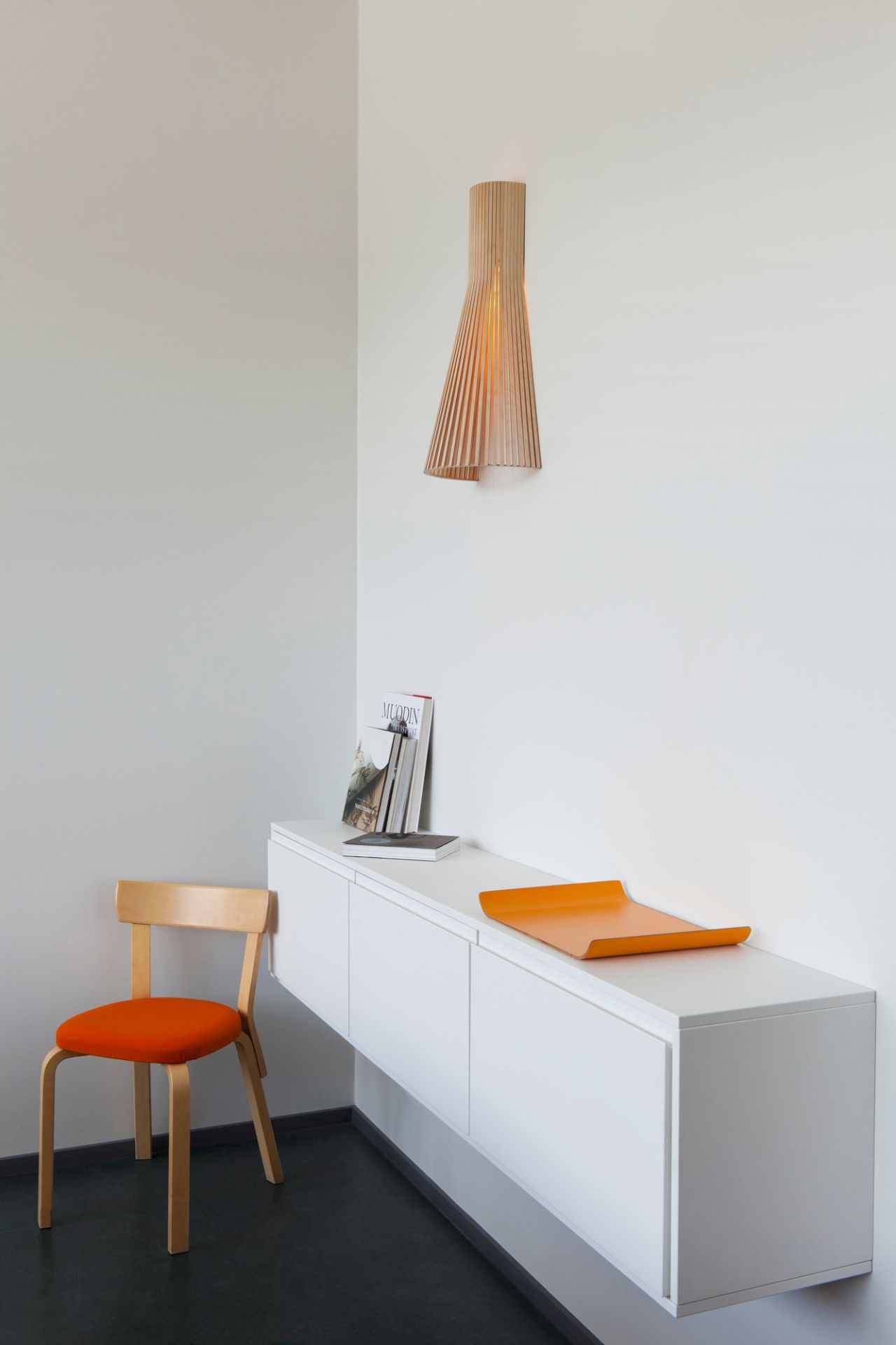 Secto Design 4230 LED Wandleuchte aus Holz an weißer Wand, minimalistisches Interieur.