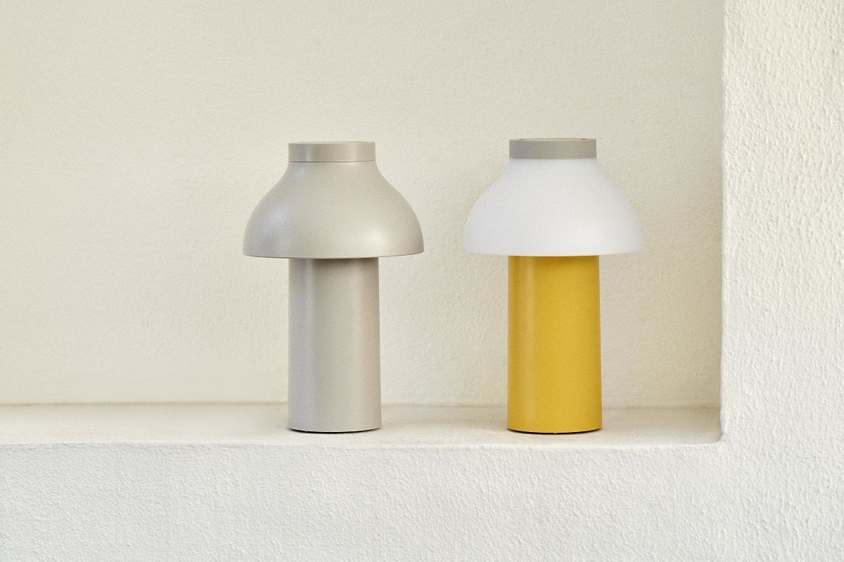 Zwei Hay Cool Portable Lampen: eine graue Akkuleuchte und eine gelbe Tischleuchte.