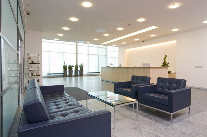 Lobby mit blauen Ledersofas, Sesseln und einem Florence Oval Table Glastisch von Knoll International.