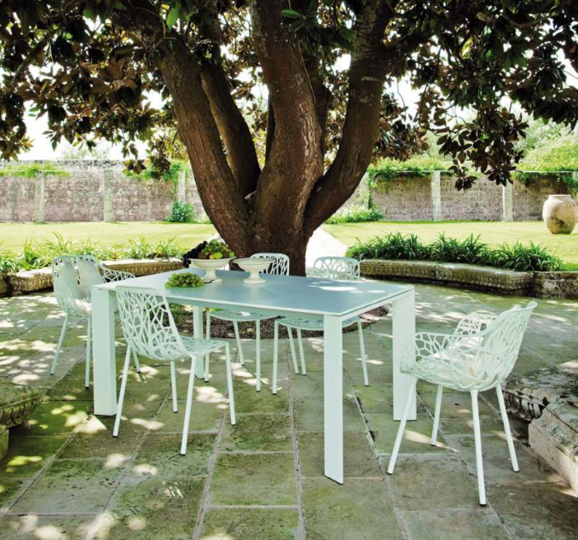 Grande Arche Outdoor Tisch von Fast mit Stühlen im Garten unter einem Baum.