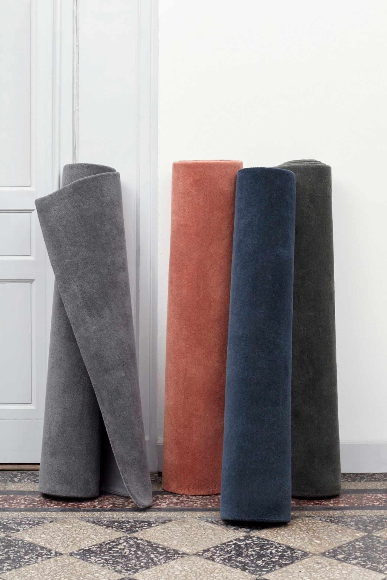 Gerollte Hay Teppiche, Raw Rug No 2, in Grau, Rot, Blau und Grün auf gemustertem Boden.