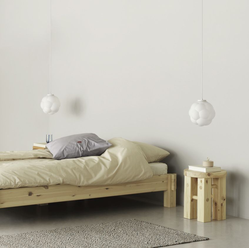 Skandinavisches Schlafzimmer mit hellem Holzbett, Pendelleuchten und Fyr Stool Hocker von Normann Copenhagen aus Kiefernholz.