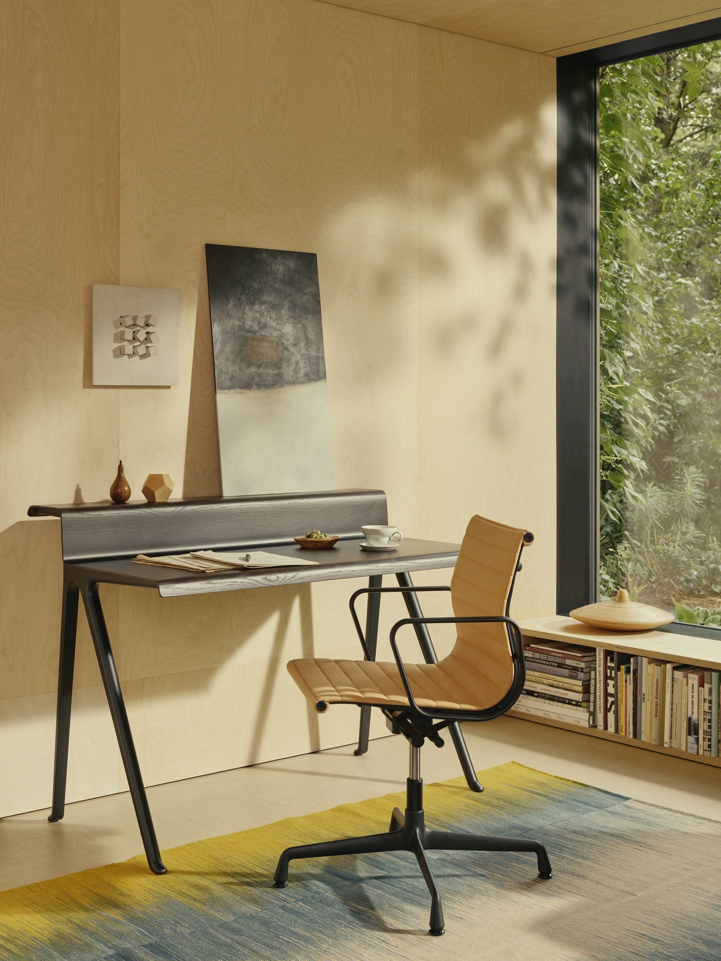 Nahaufnahme eines Vitra Aluminium Chair EA 131 Bürostuhls in einem modern eingerichteten Arbeitszimmer mit Schreibtisch.