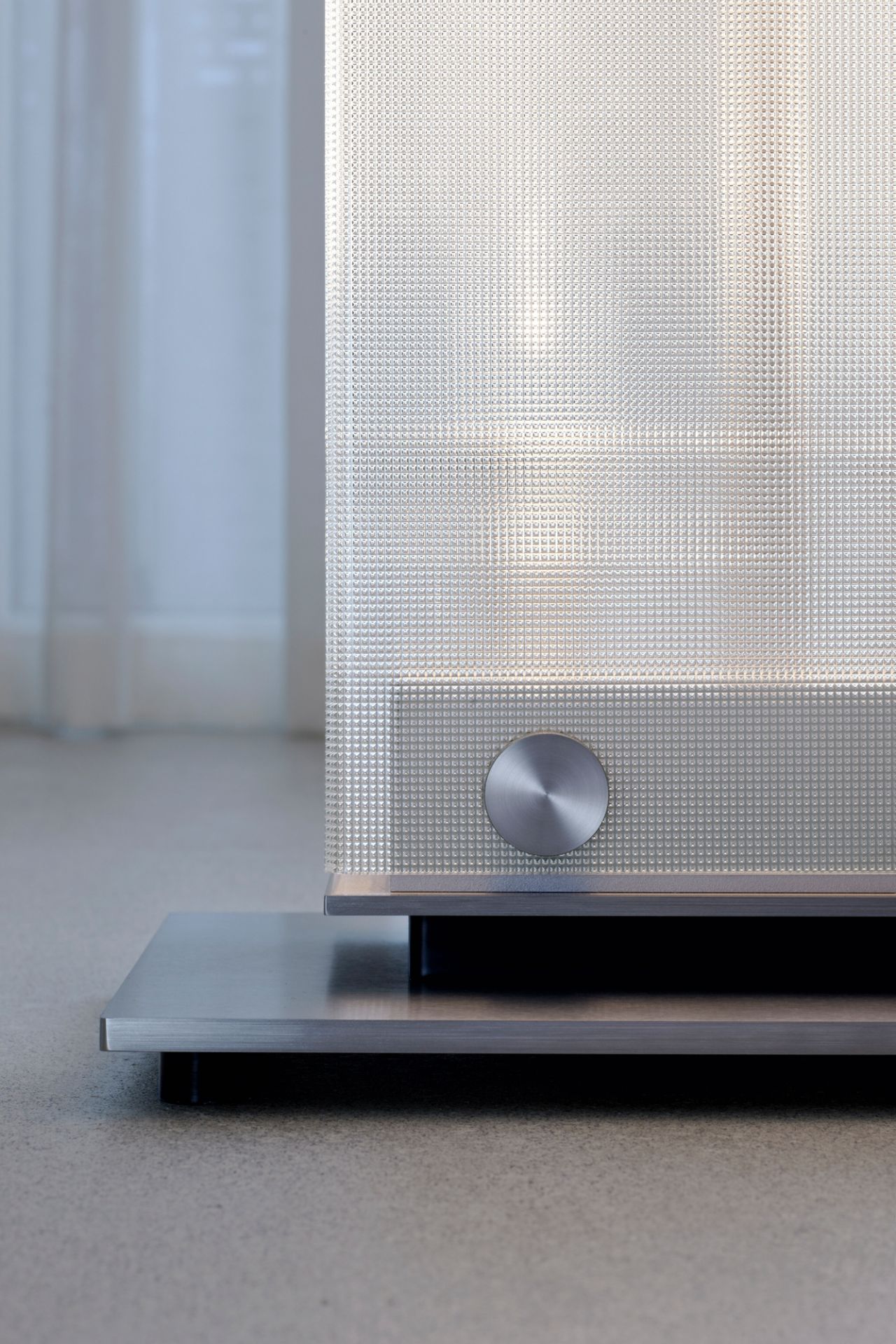 Detailaufnahme der Twilight LED Stehleuchte von Belux mit strukturiertem Glasdiffusor und silbernem Fuß.