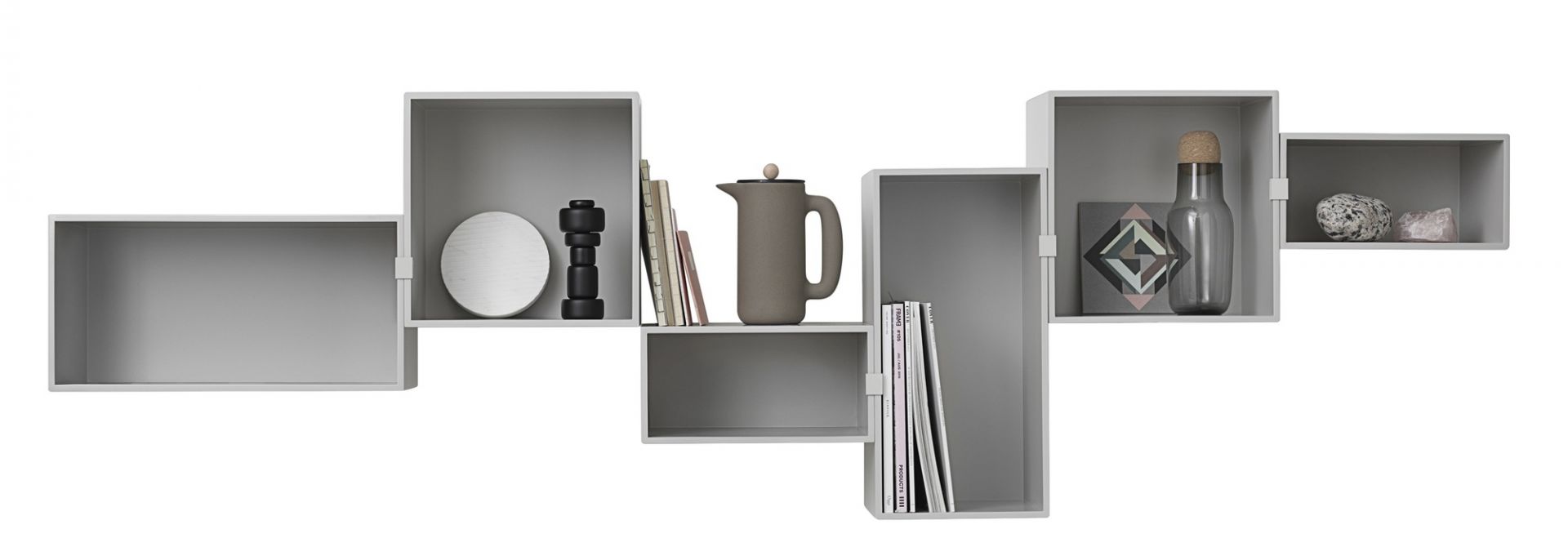 Graues Mini Stacked Regalsystem von Muuto mit Deko-Objekten wie Kanne, Flasche, Büchern und Steinen.