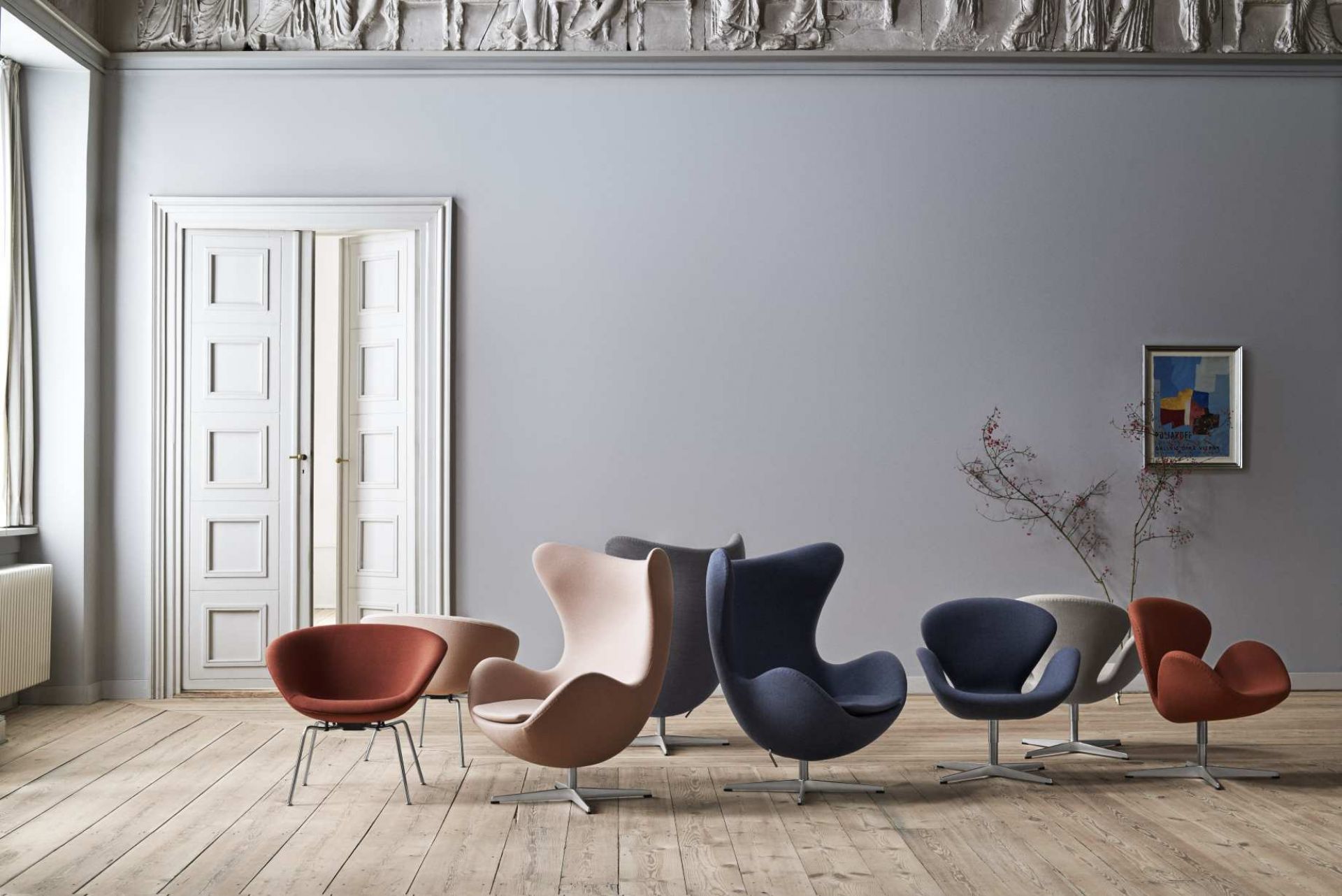 Fritz Hansen Sessel Kollektion: Pot Sessel und Egg Chair in verschiedenen Farben auf hellem Holzboden.