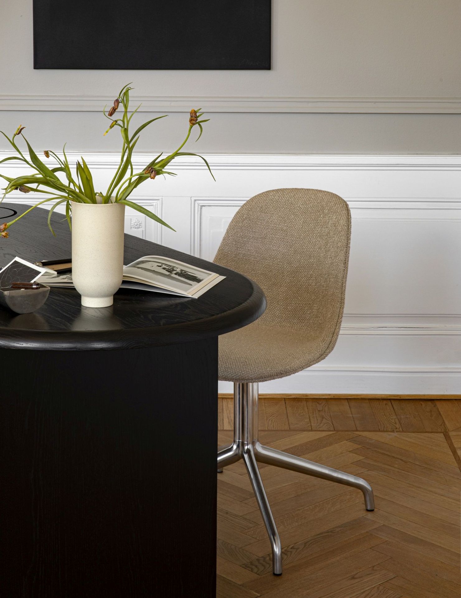 Detailaufnahme des Audo Copenhagen Eclipse Desk Schreibtischs in Schwarz mit Stuhl und Dekoration im stilvollen Interieur.