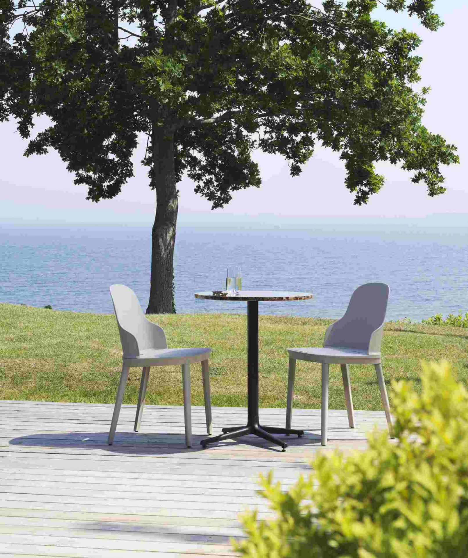 Zwei graue Allez Chair PP Stühle von Normann Copenhagen auf einer Holzterrasse mit Meerblick.