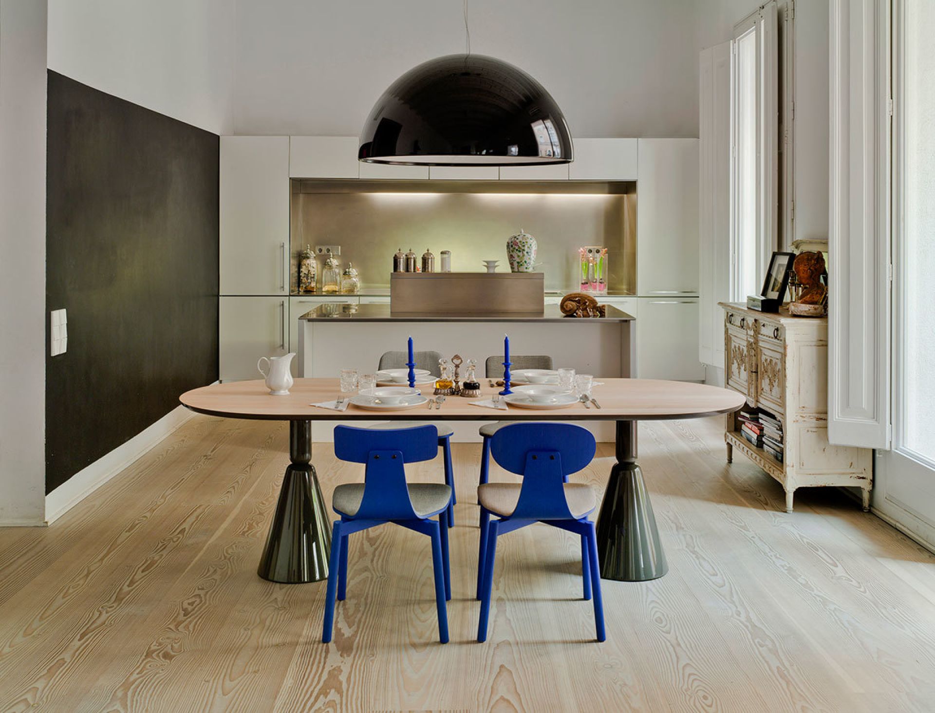 Esszimmer mit ovalem Holztisch, blauen Stühlen und Design-Lampe. Sancal Pion Esstisch im modernen Interieur.