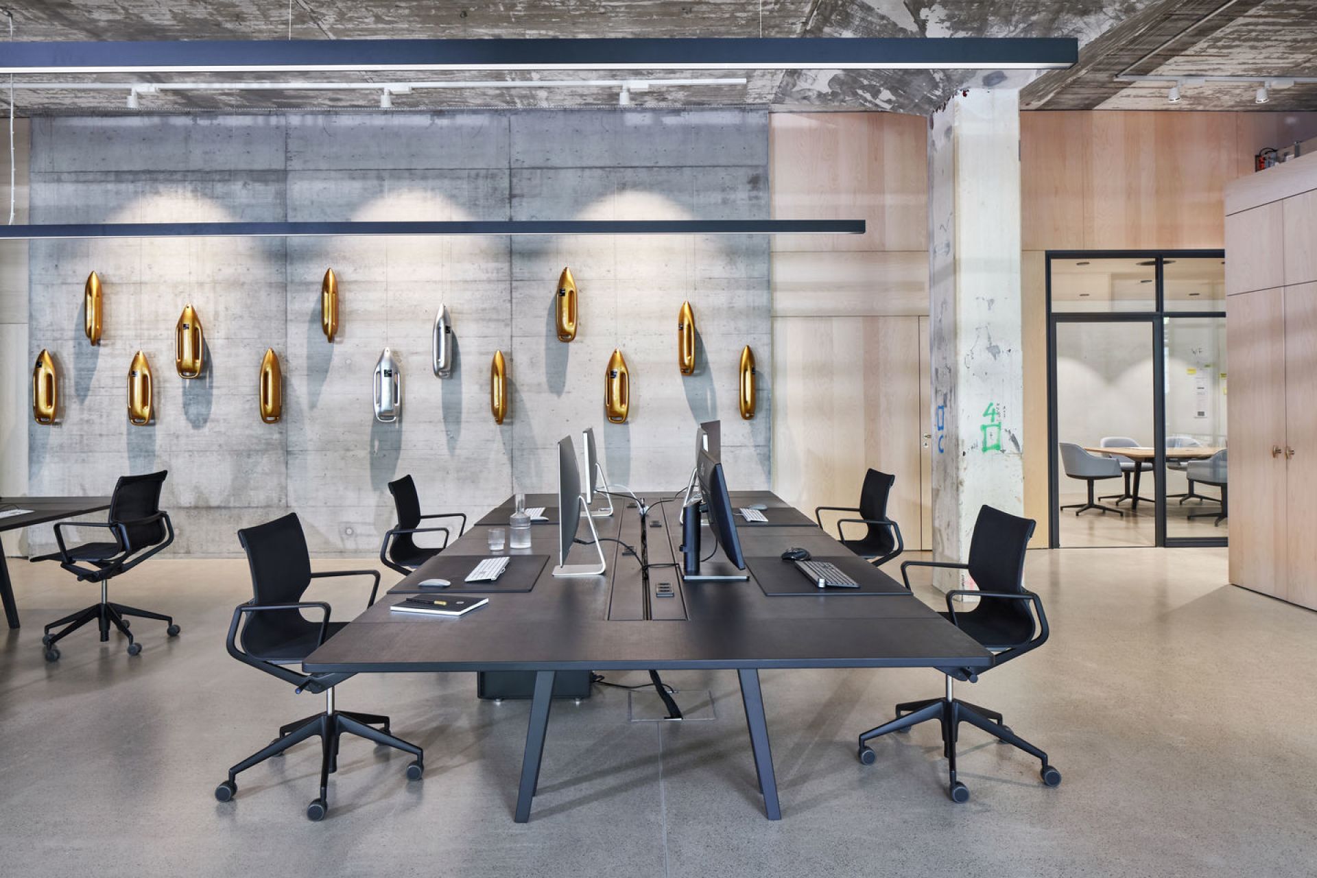 Moderner Büroraum mit schwarzem Konferenztisch und Physix Studio Bürodrehstühlen von Vitra für ergonomisches Sitzen.