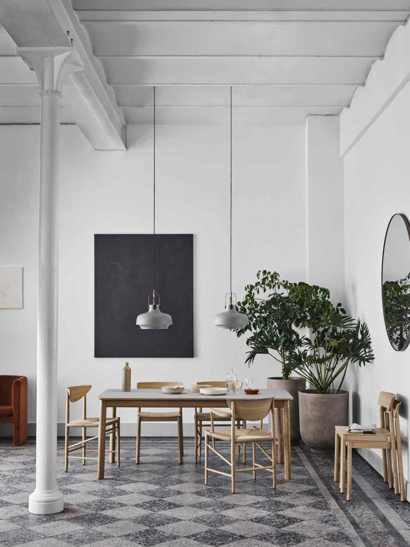 Esszimmer mit AndTradition Amore Spiegel, rund, schwarz gerahmt, an weißer Wand. Dekorative Spiegel für stilvolles Wohnen.