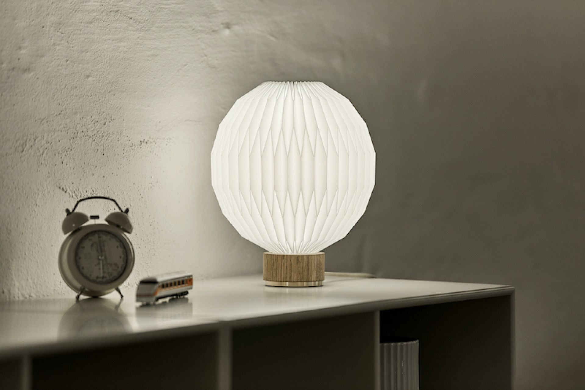 Le Klint Tischleuchte Model 375 mit Eichenfuß und plissiertem Papierschirm.
