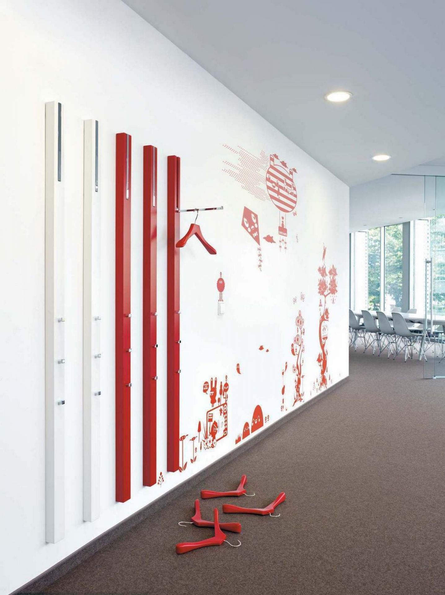 Schönbuch Garderobenleisten 0112 in Weiß und Rot an Wand mit roter Wanddekoration und roten Kleiderbügeln.
