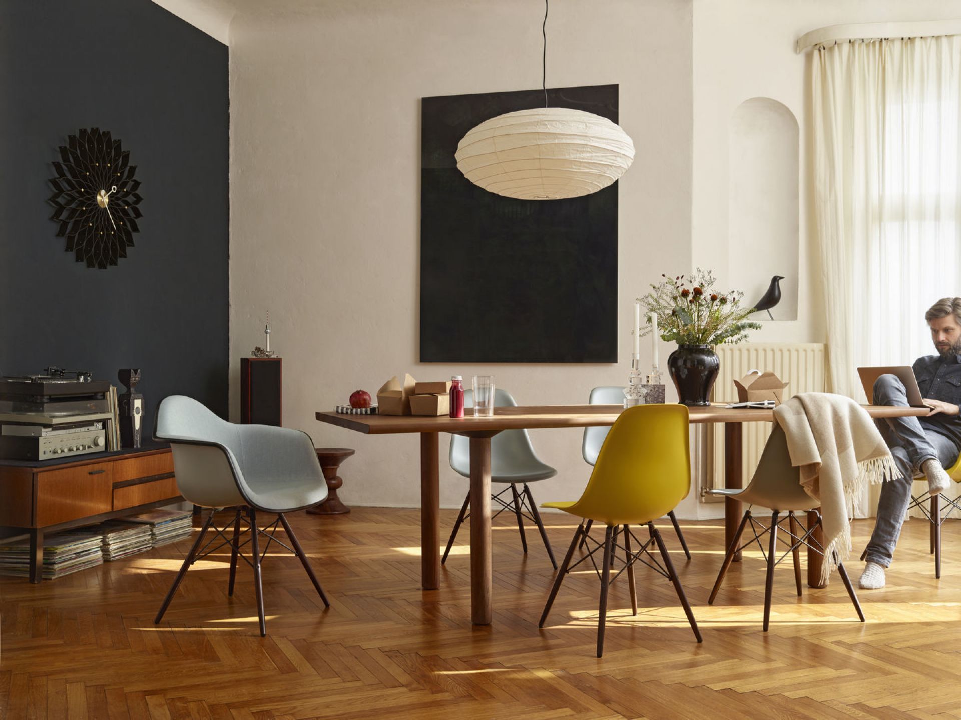 Esszimmer mit Holztisch und mehreren Eames Plastic Arm Chairs DAW Stühlen von Vitra.