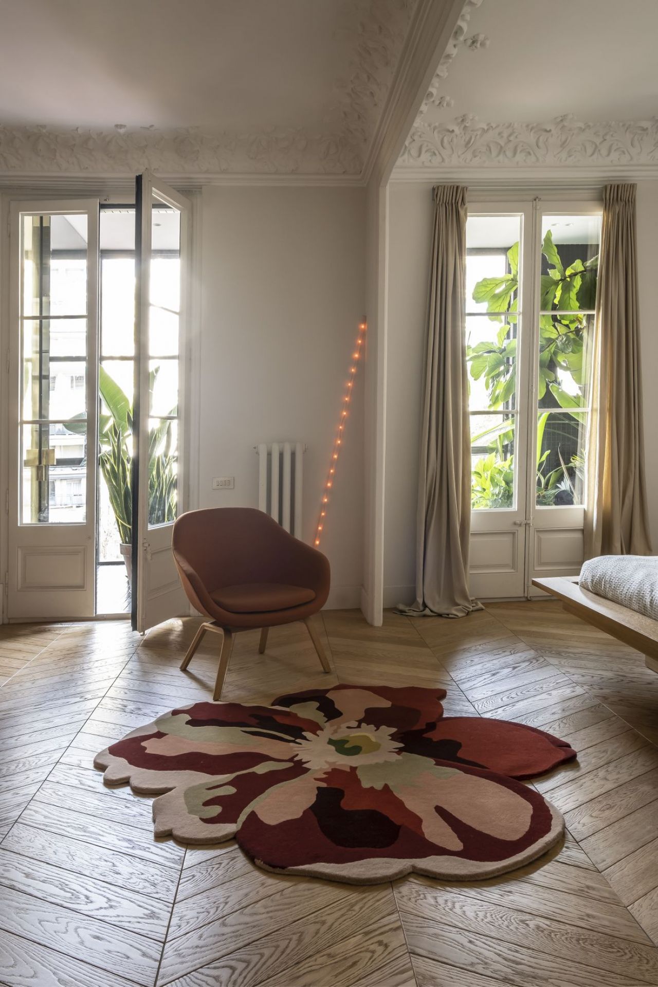 Nanimarquina Flora Bloom Teppich im Raum mit Sessel. Design Teppich in Blumenform.