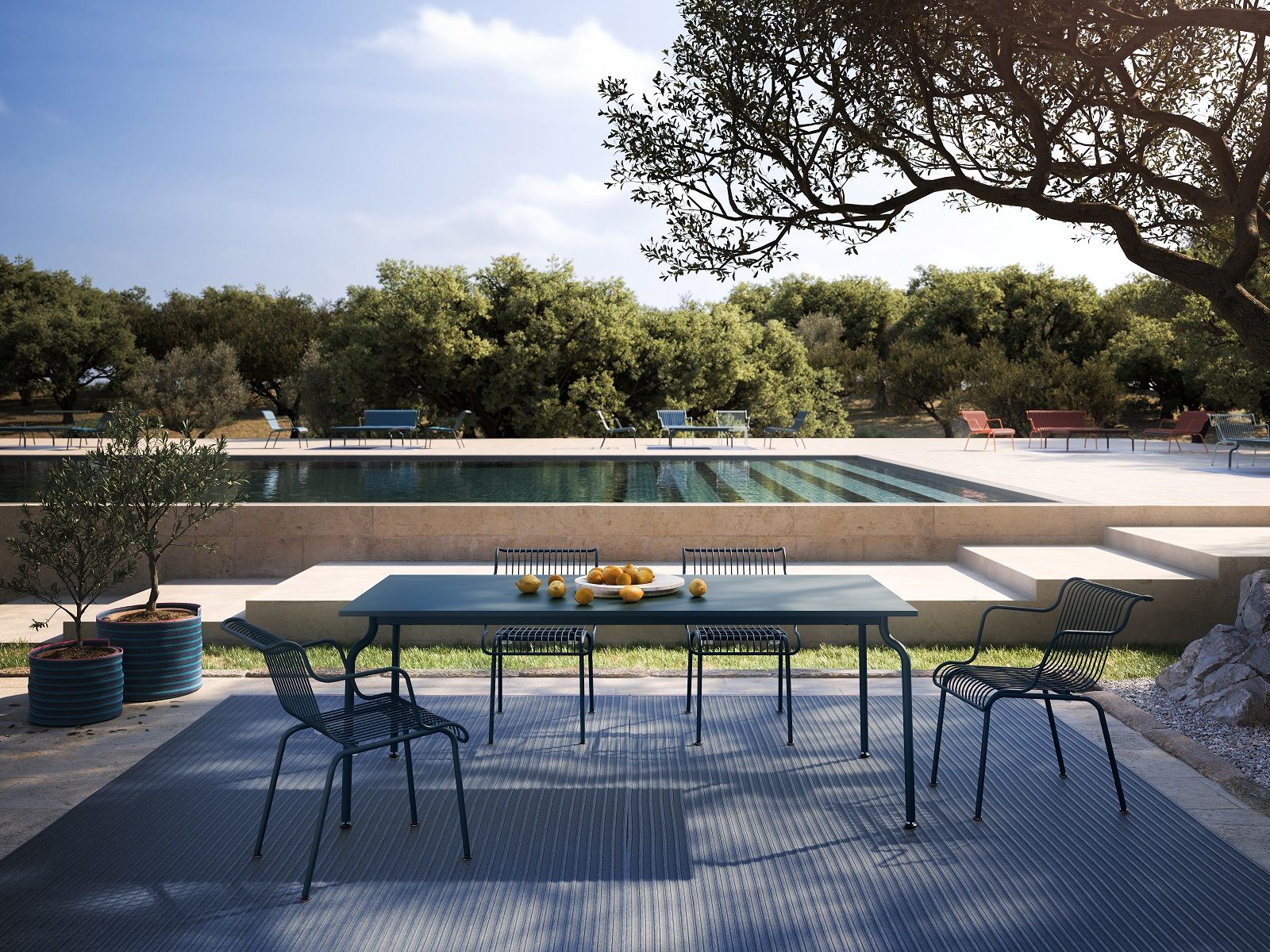 South Outdoor Esstisch von Magis neben Pool. Moderner Gartentisch mit Stühlen für Mahlzeiten im Freien.