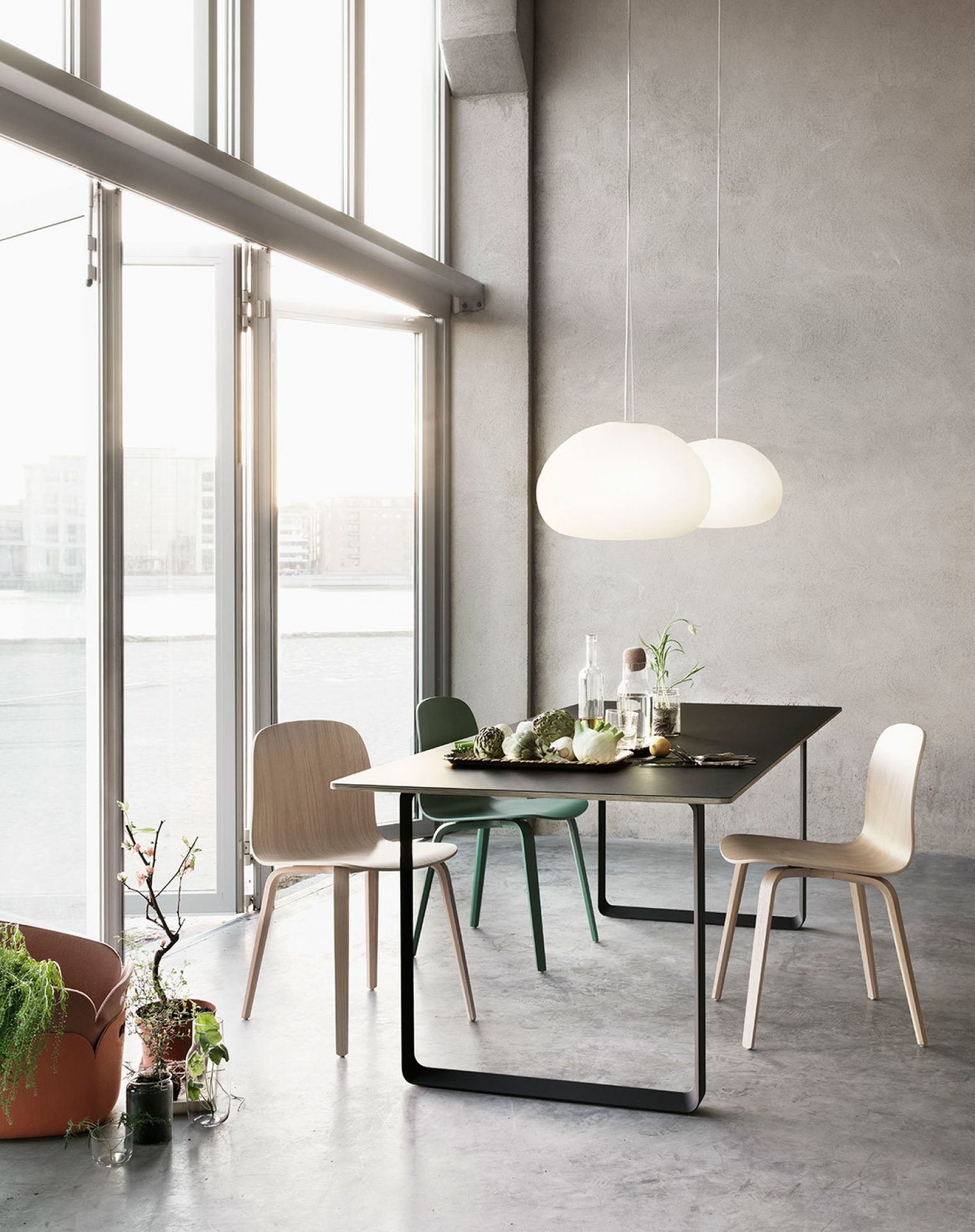 Muuto Visu Chair Wood Base Stuhl in hellem Holz und Grün am Esstisch.