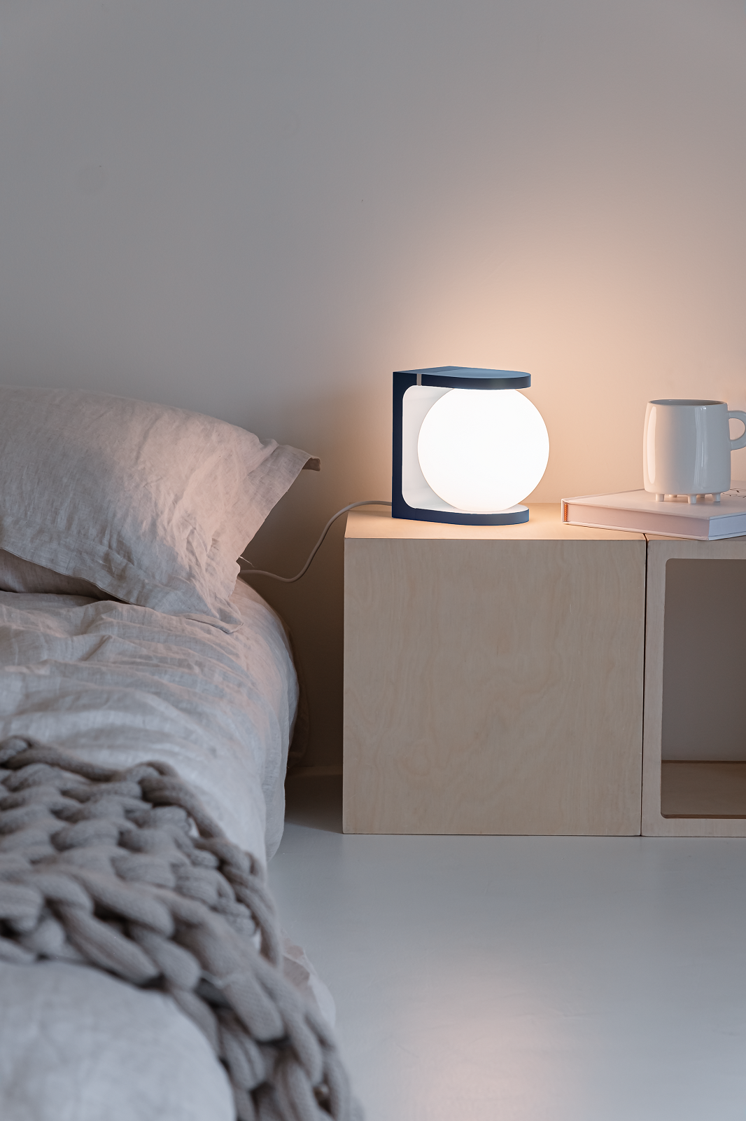 Plat Reading Lamp Tischleuchte von house of home auf Nachttisch neben Bett.