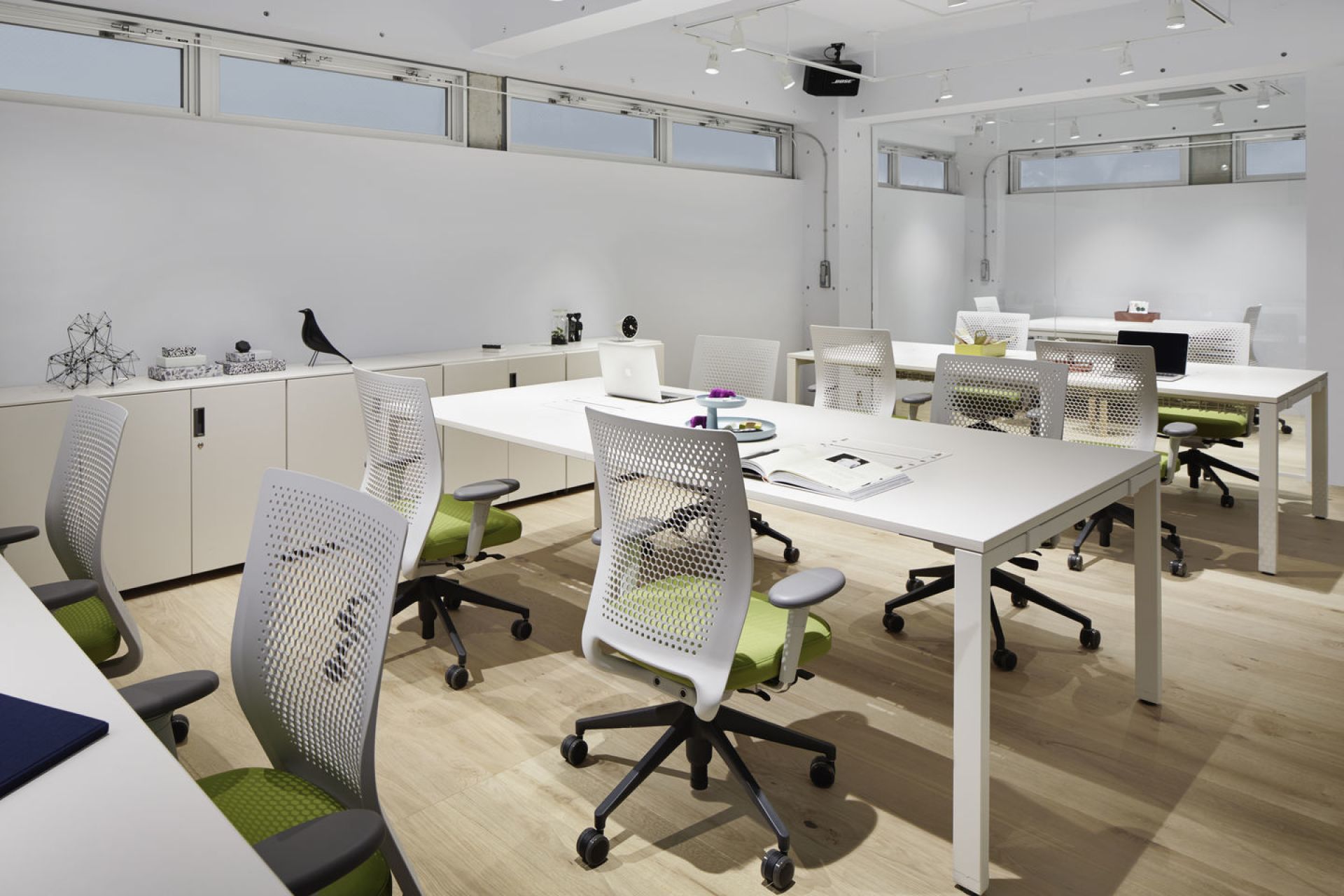 Heller Büroraum mit mehreren weißen ID Air Bürodrehstühlen von Vitra und weißen Tischen.
