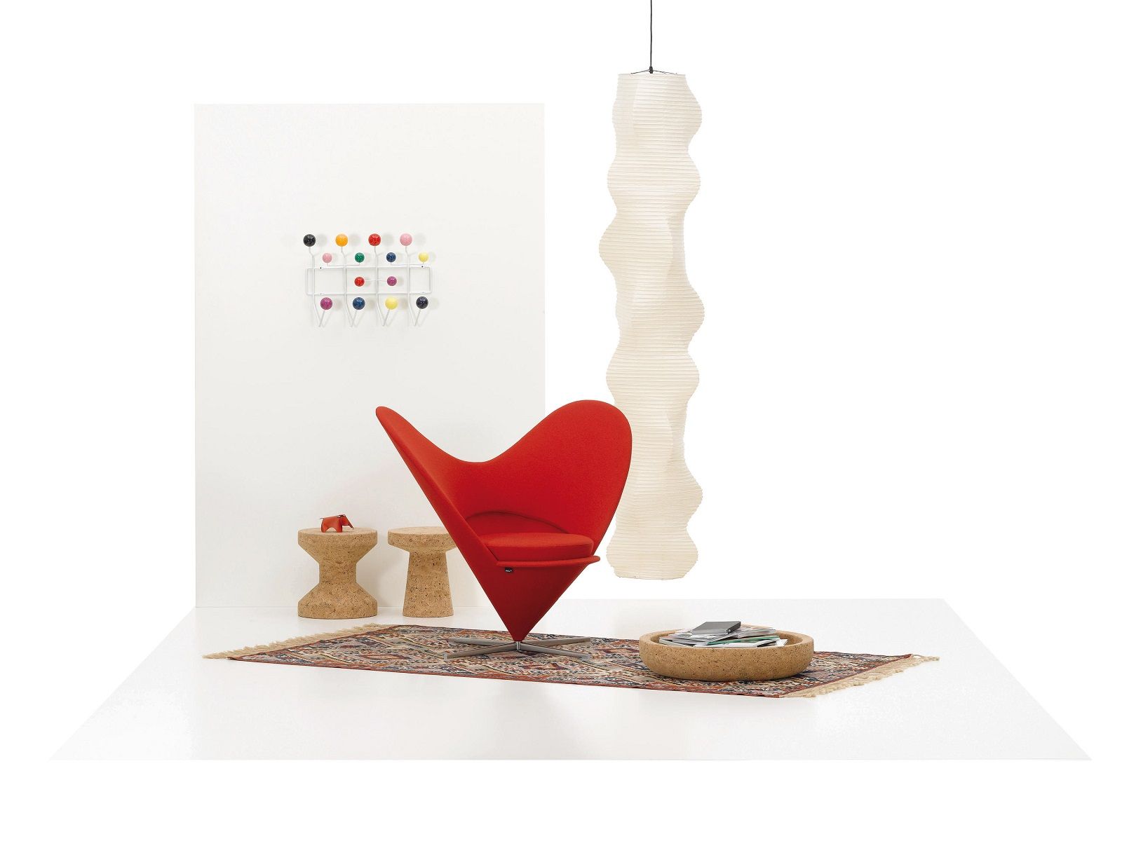 Innenraum mit rotem Sessel, Kork-Hocker/Tisch (Cork Family) und Teppich. Design-Möbel und Wohnaccessoires.