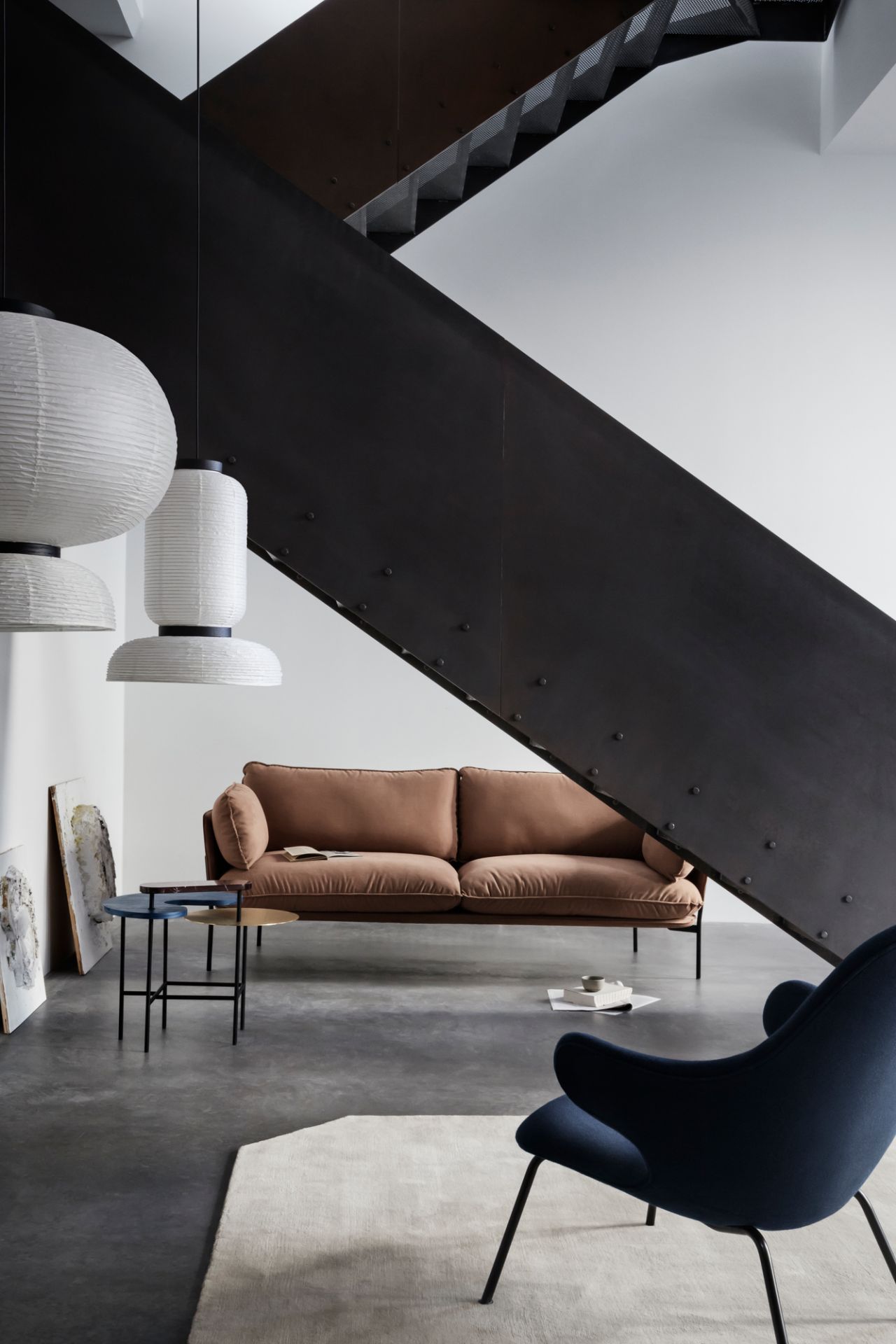 AndTradition Cloud Sofa, braunes 2-Sitzer Sofa im modernen Wohnzimmer mit Treppe und Designermöbeln.