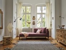 Vitra Kissen auf Sofa in hellem Wohnzimmer mit Teppich und Kommode. Dekorative Sofakissen in Rosa.