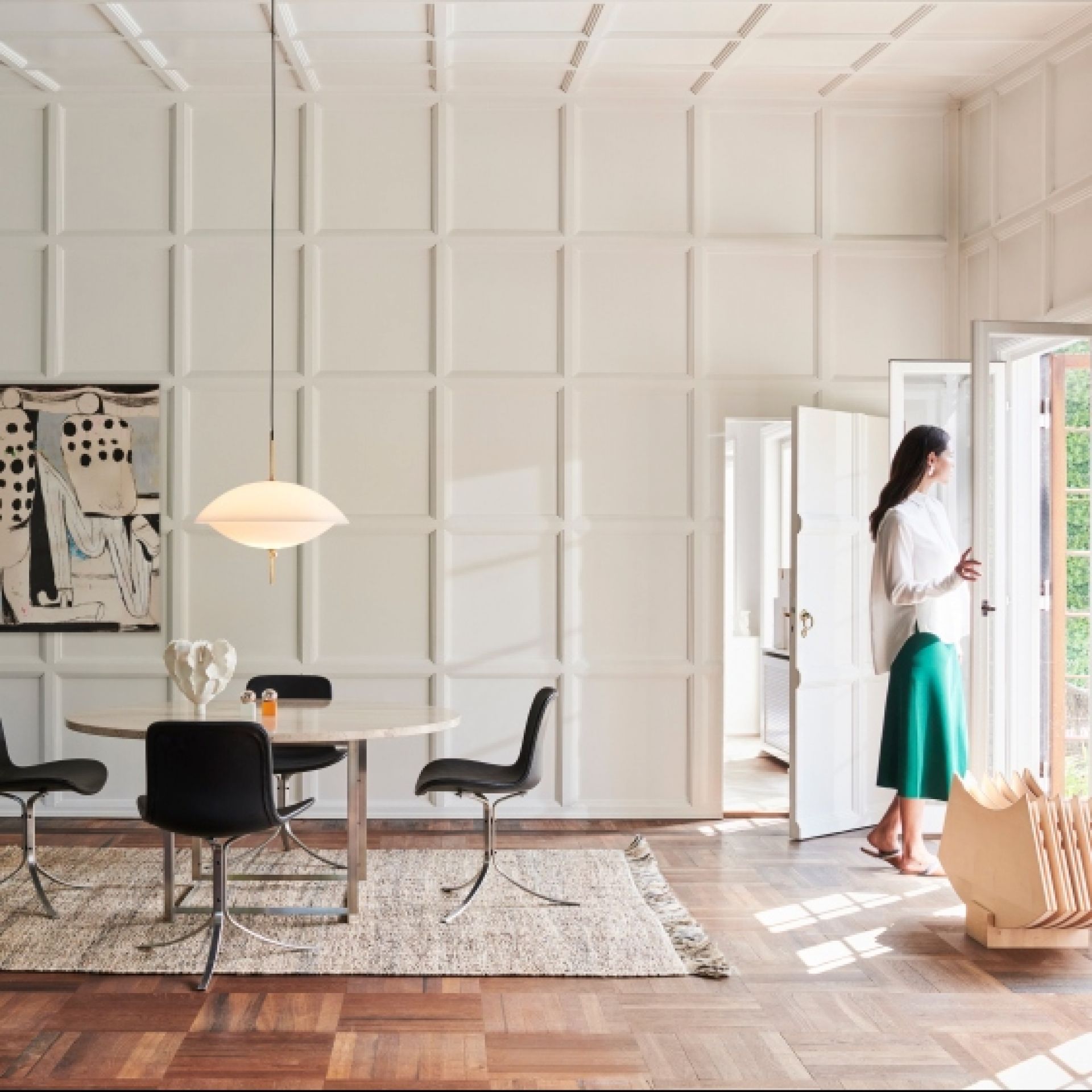 Helle Clam Pendelleuchte von Fritz Hansen über Esstisch in modernem Wohnzimmer.