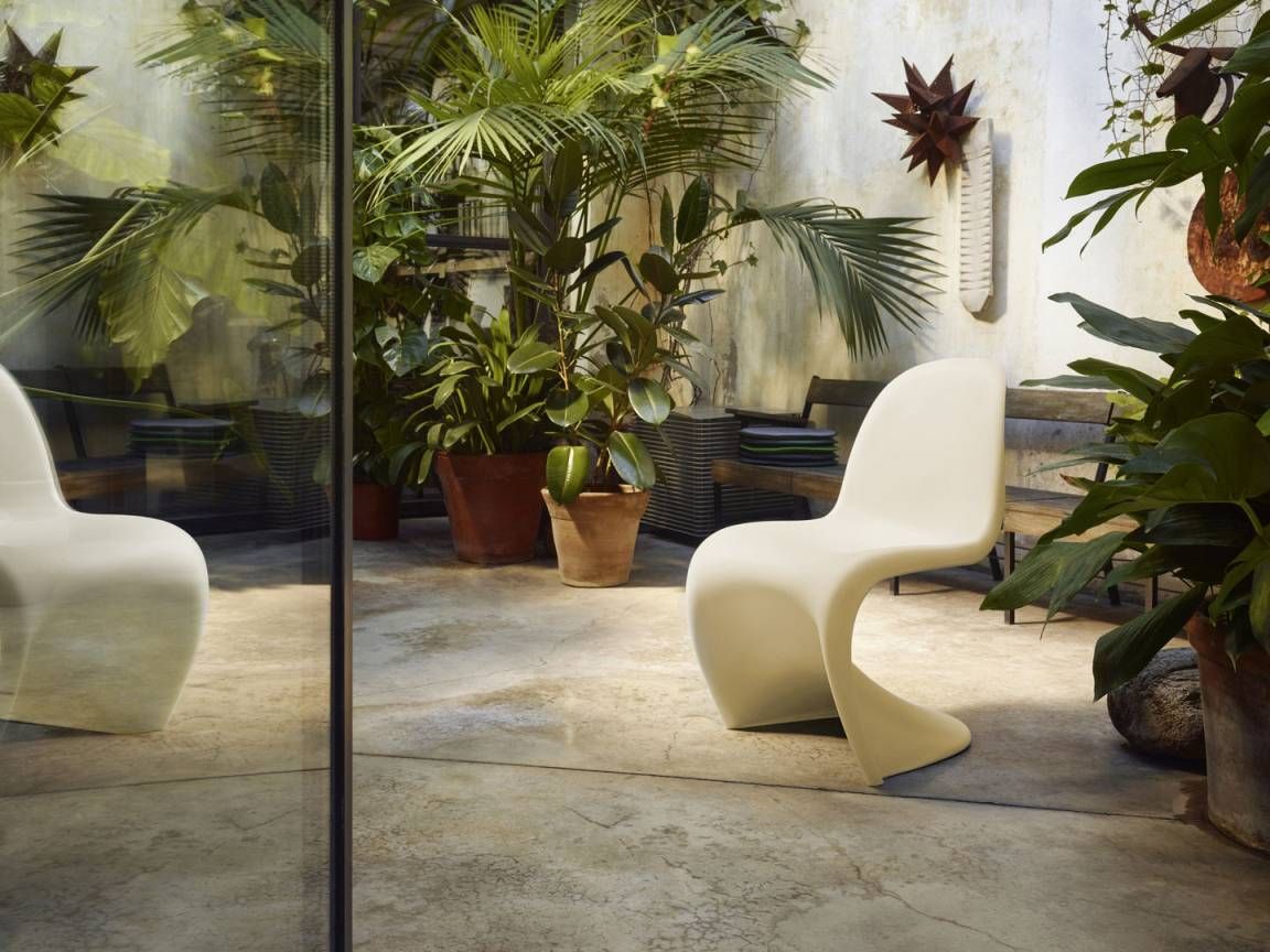 Beiger Panton Chair Kunststoffstuhl von Vitra, Special Version, im Garten mit Pflanzen. Designklassiker.