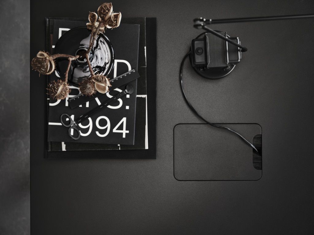 Detailaufnahme des schwarzen Works Schreibtisch Fix B140cm von String Furniture mit stilvollen Büroaccessoires und integrierter Kabelführung.