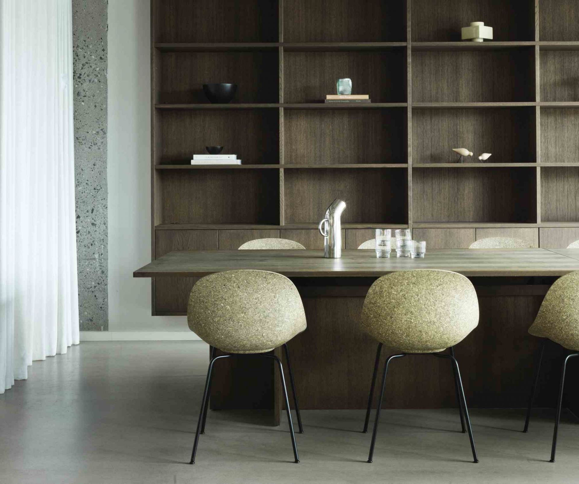 Mat Chair Steel Stuhl von Normann Copenhagen am Esstisch, minimalistisches Design mit olivgrüner Sitzschale und Stahlgestell.