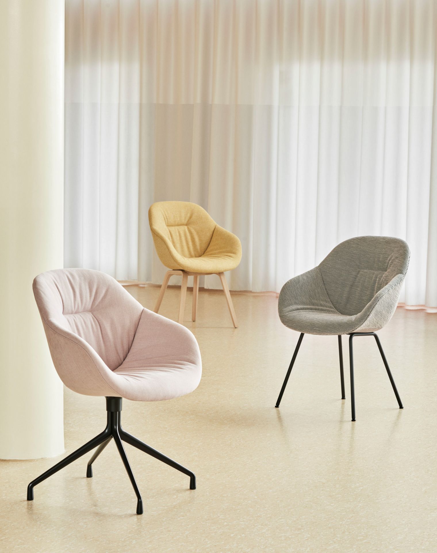 Drei Hay About a Chair AAC123 Soft Duo Stühle in Rosa, Gelb und Grau im Raum.