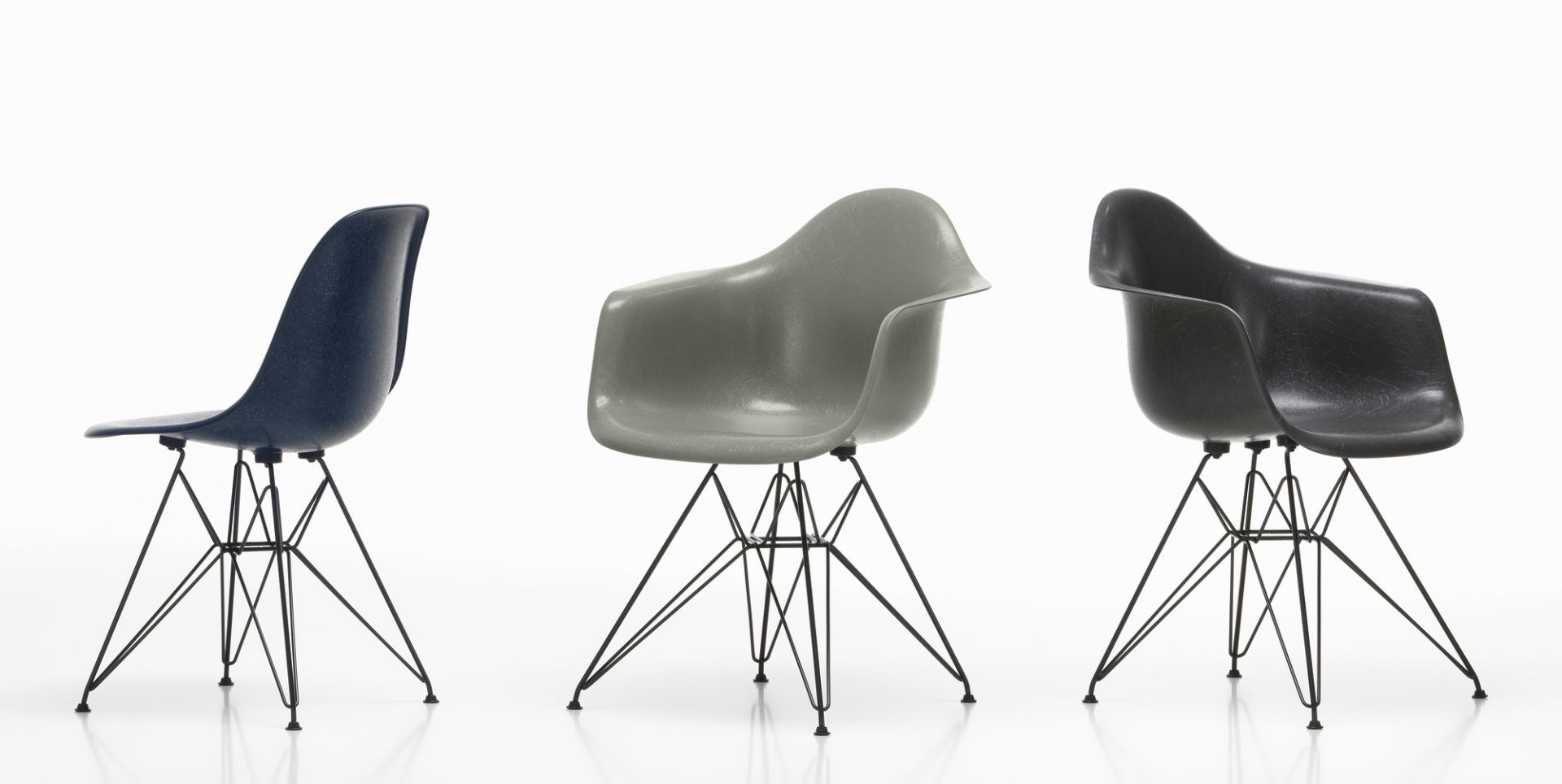 Drei Eames Fiberglass Arm Chairs DAR Stühle von Vitra in Blau, Grau und Schwarz.