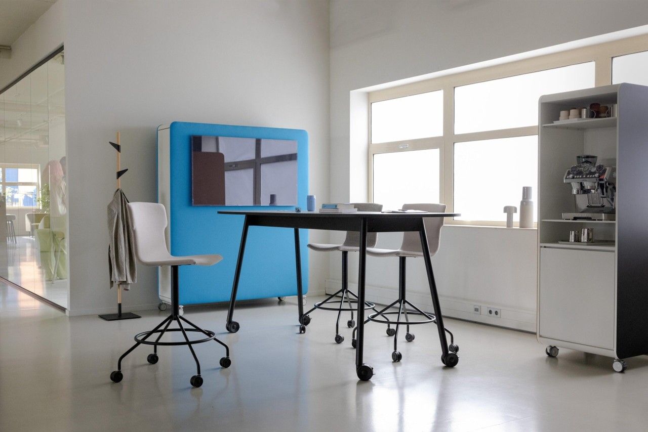 Heller Büroraum mit Cascando Co-Chair Bürodrehstuhl, Stehtisch und blauer Akustikwand für moderne Arbeitsplätze.