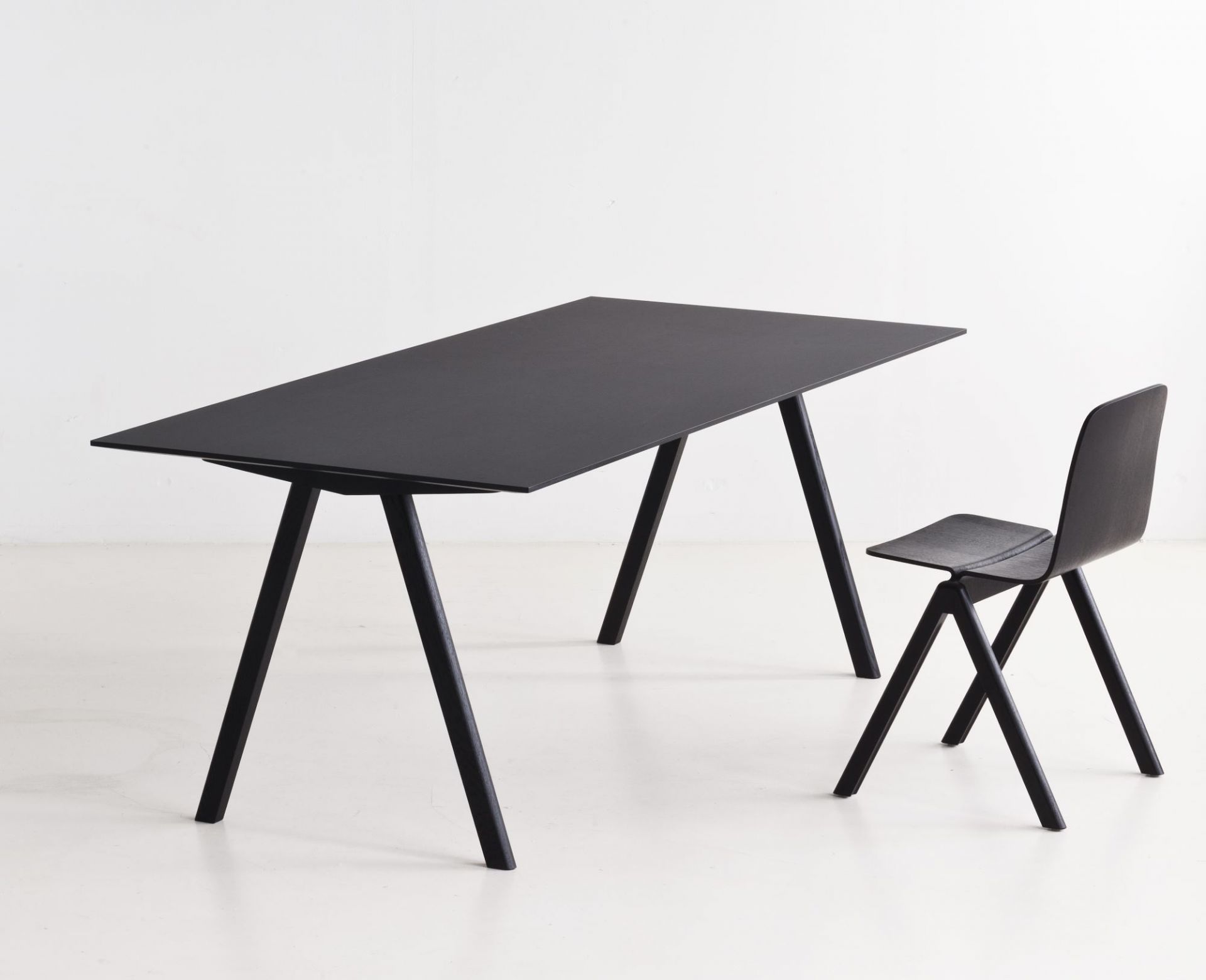 Schwarzer Copenhague Table CPH 10 Tisch von Hay mit passendem Stuhl vor weißem Hintergrund.