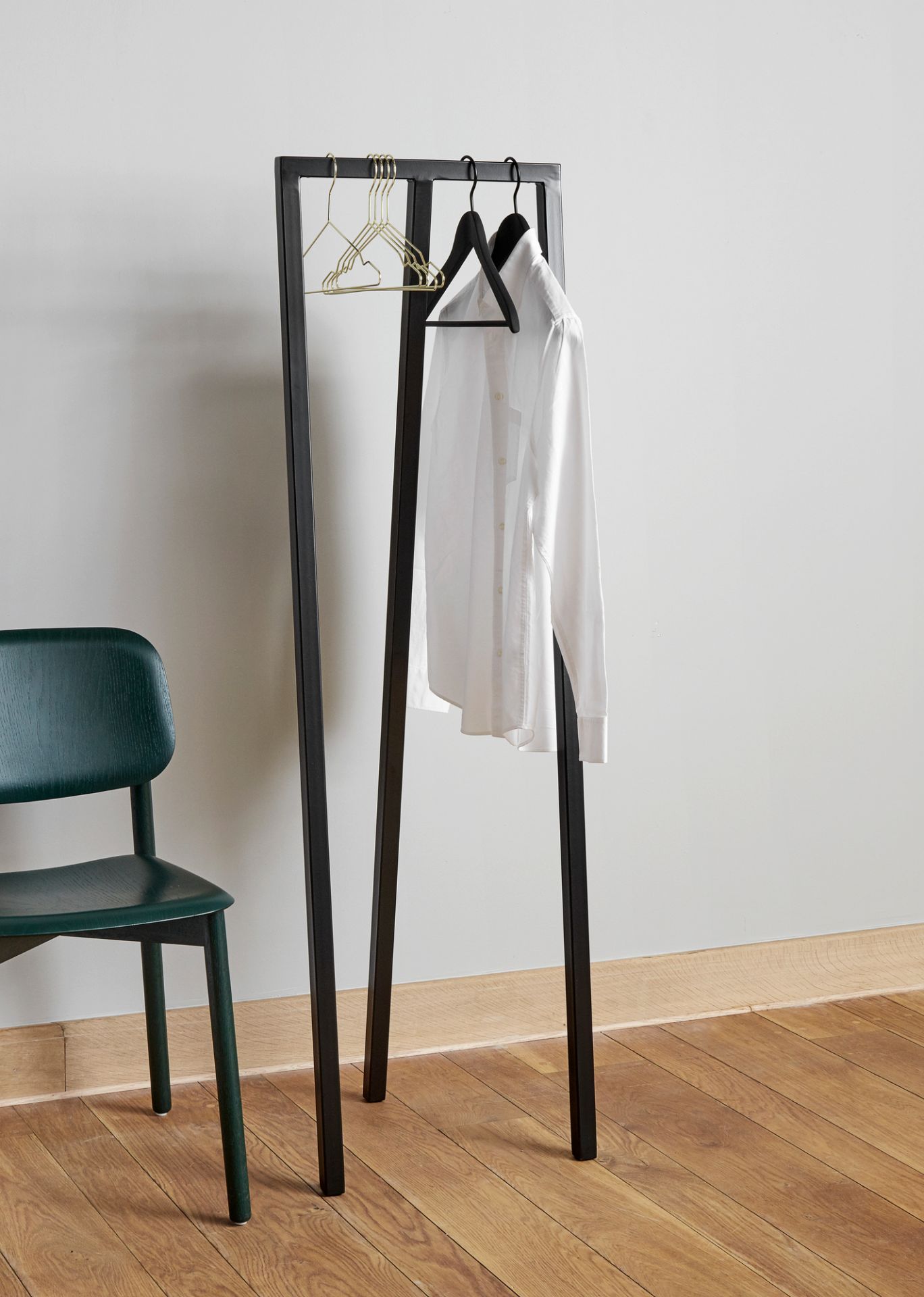Hay Soft Edge 60 Stuhl in Grün neben einem schwarzen Kleiderständer mit Hemd und Kleiderbügeln.