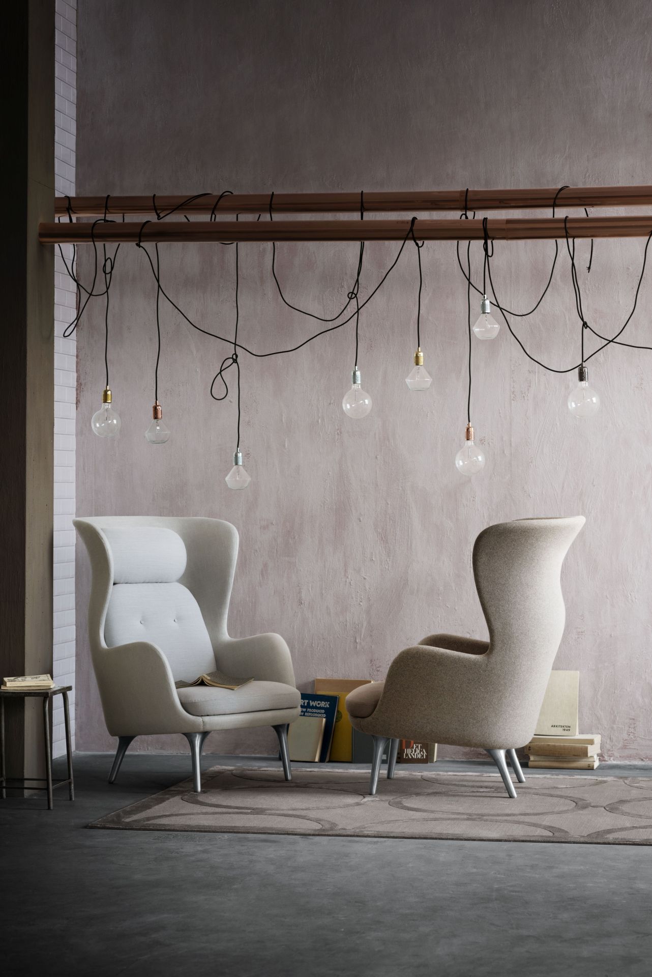 Zwei Ro Sessel von Fritz Hansen aus Holz in beigen Farbtönen vor einer Wand.
